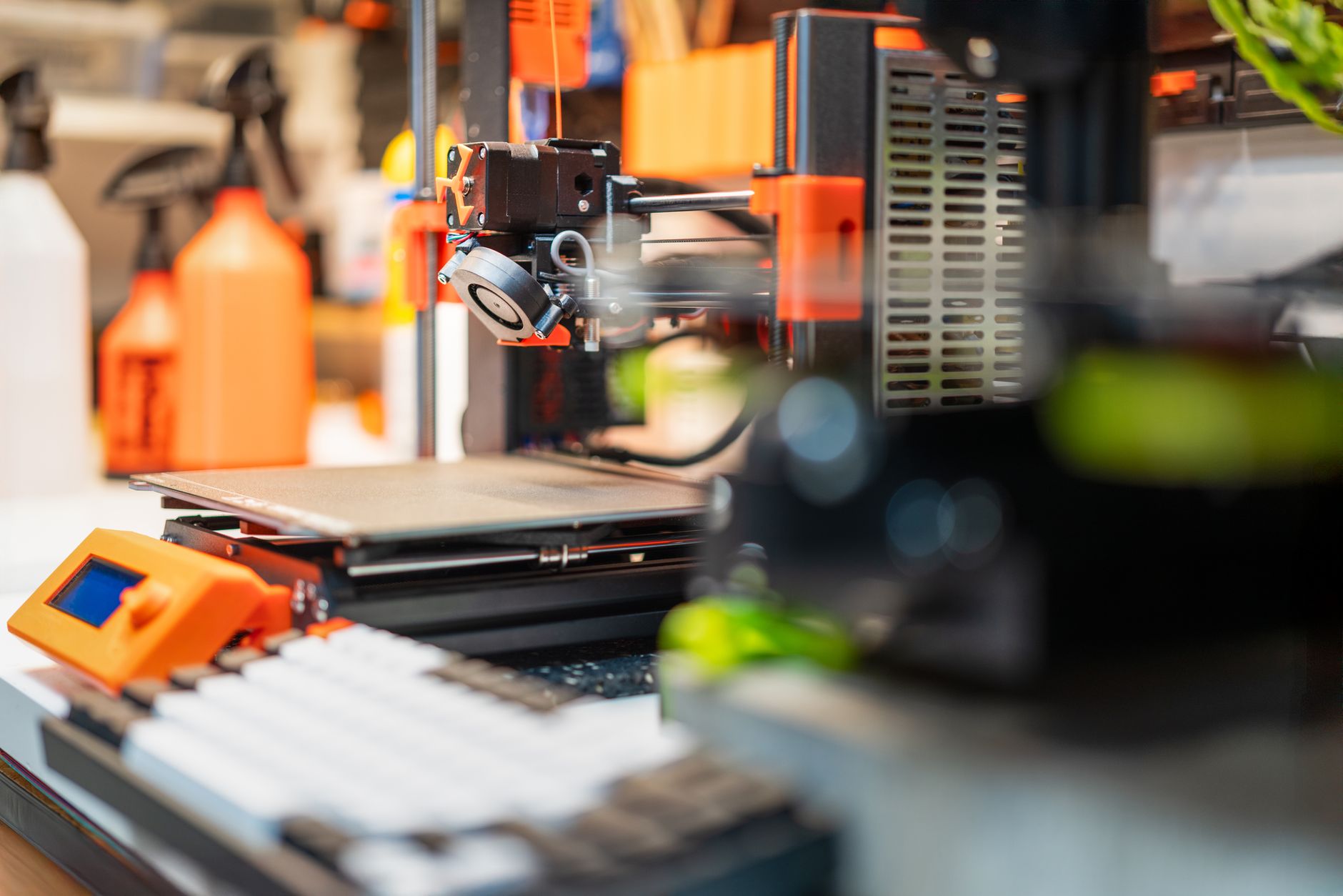 Detailed view of a 3D printer in a busy workshop, showcasing modern 3D printing technology and equipment.