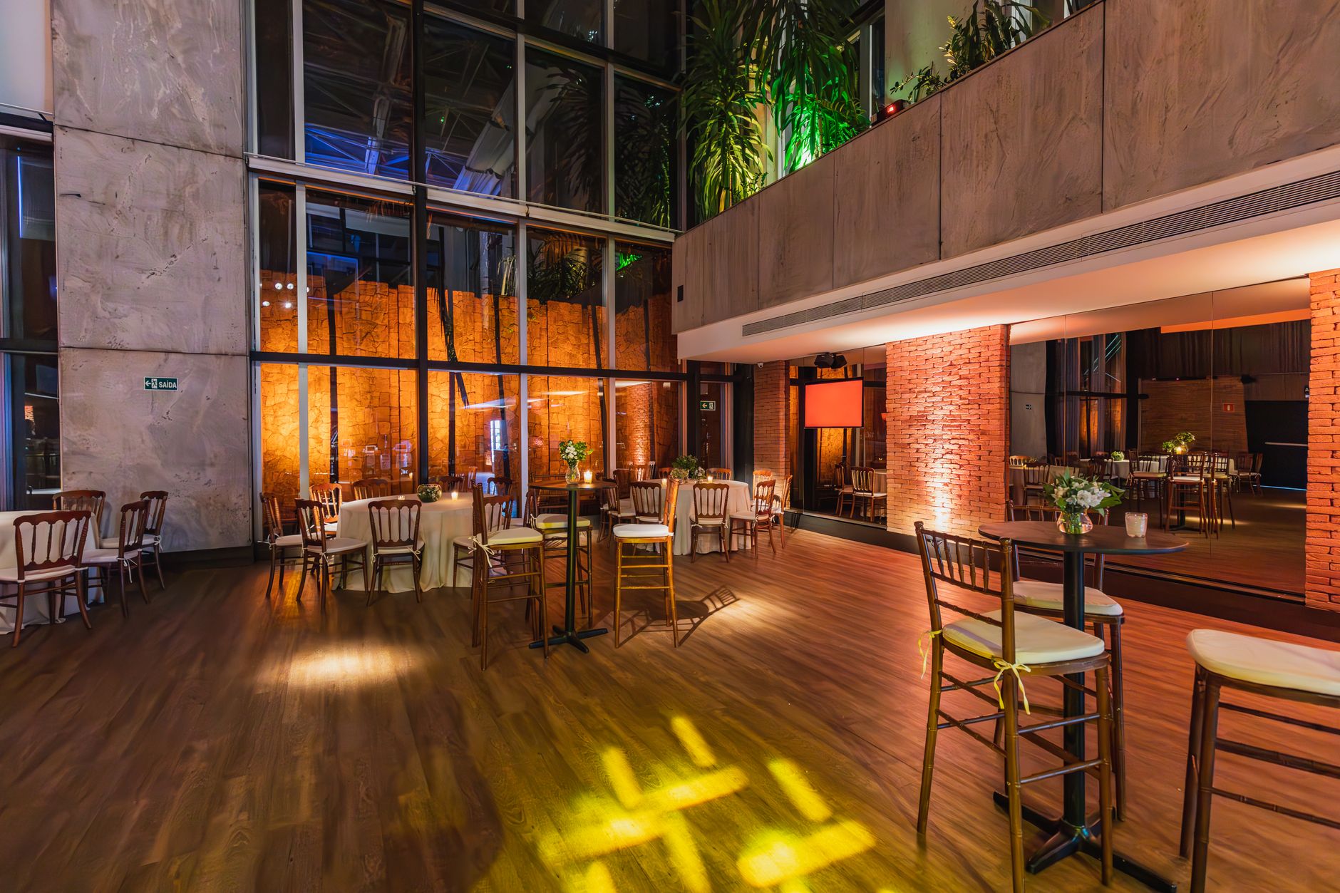 Spacious modern banquet hall with elegant decor and ambient lighting, ready for a celebratory event.