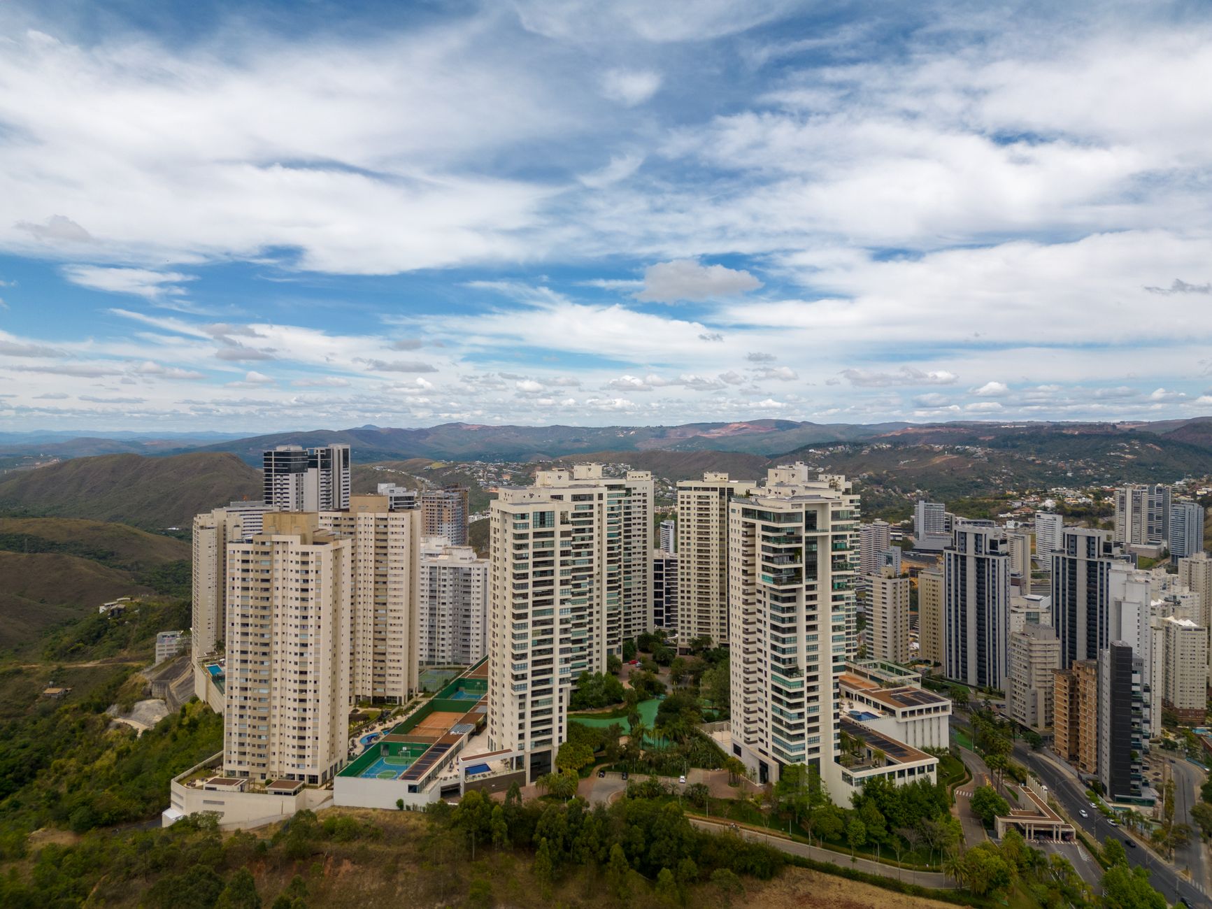 Cityscape of Belo Horizonte with skyscrapers and mountains in the background.