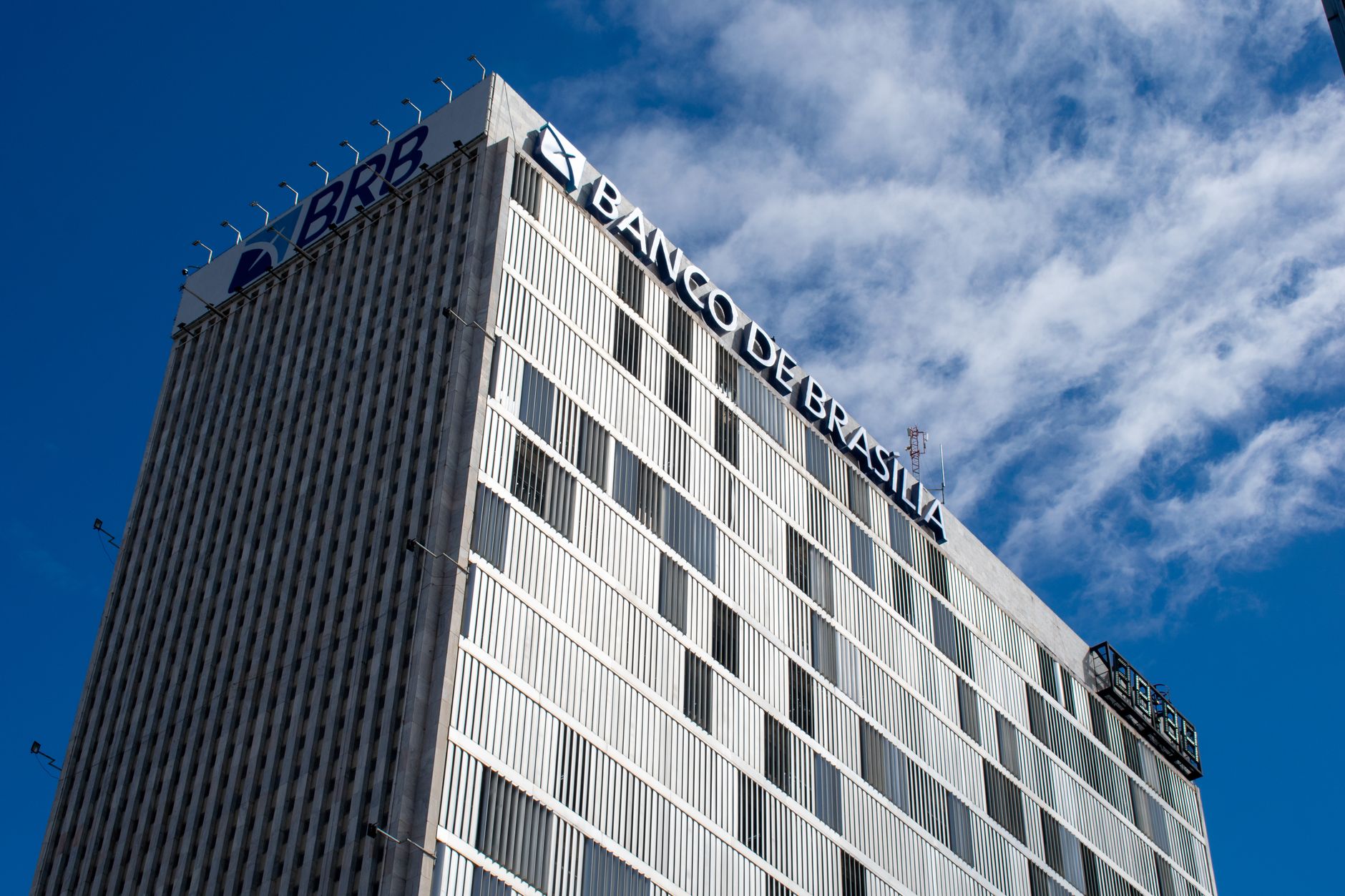Skyward view of the Banco de Brasília, an iconic modern building in Brazil's capital, under a clear sky.