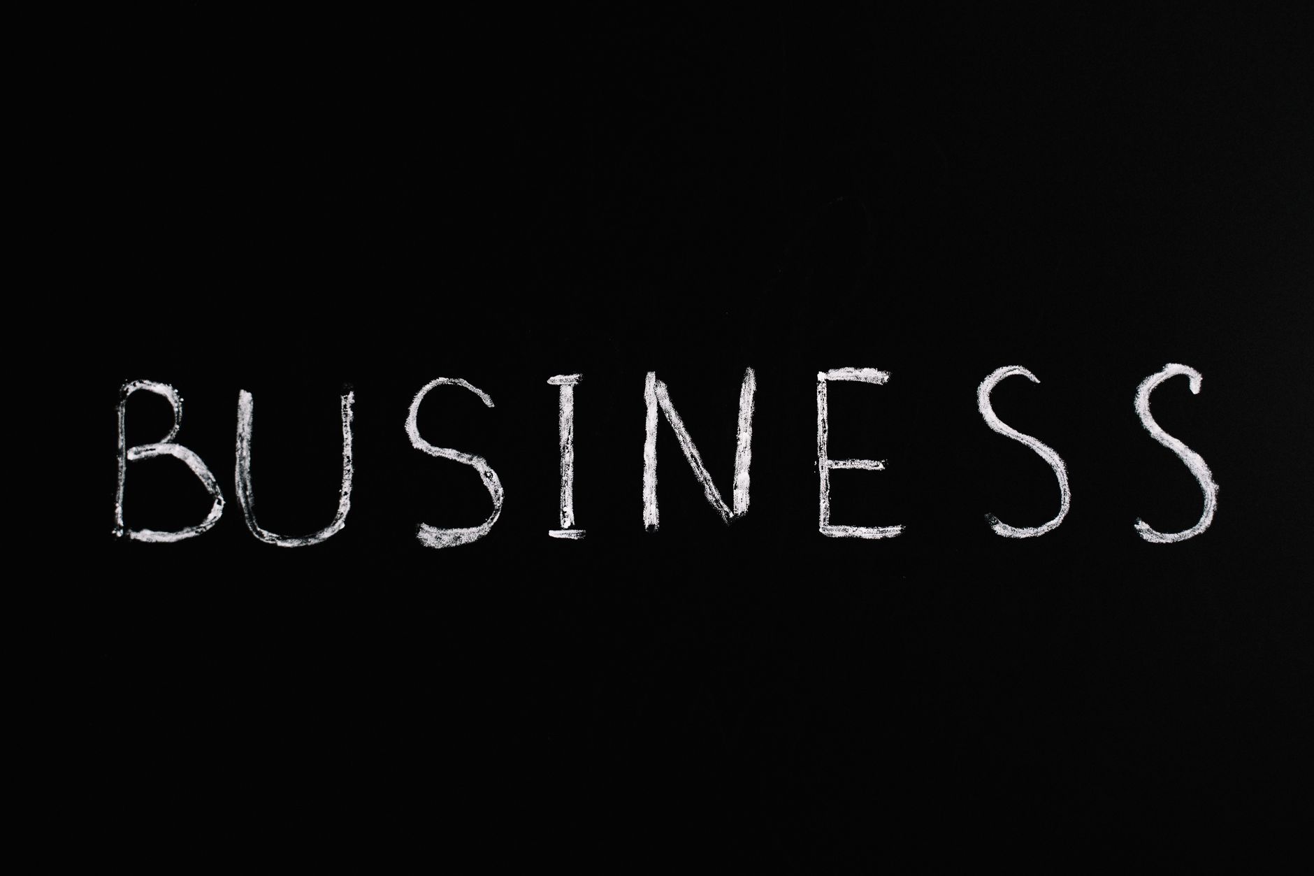 White chalk letters spelling 'BUSINESS' on a blackboard. Simple yet powerful conceptual design.