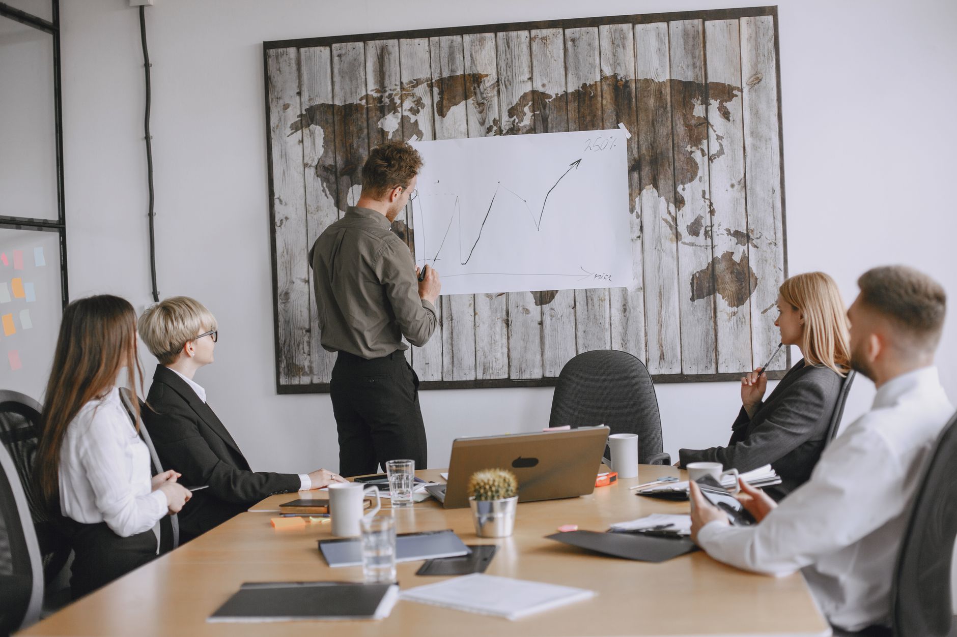 Group of business professionals discussing strategies with growth chart in conference room.