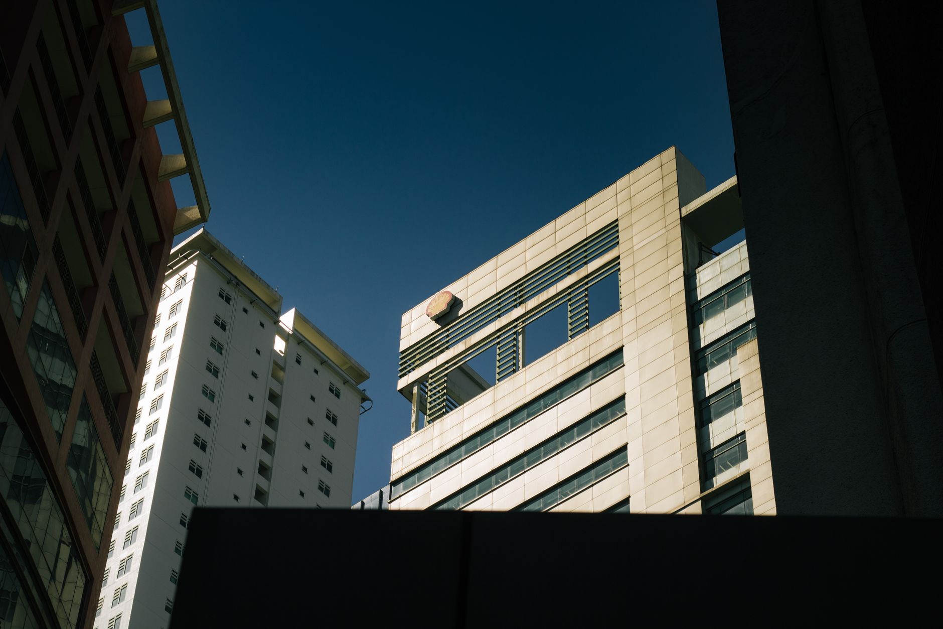 Low-angle view of modern skyscrapers with clear blue sky in an urban setting.