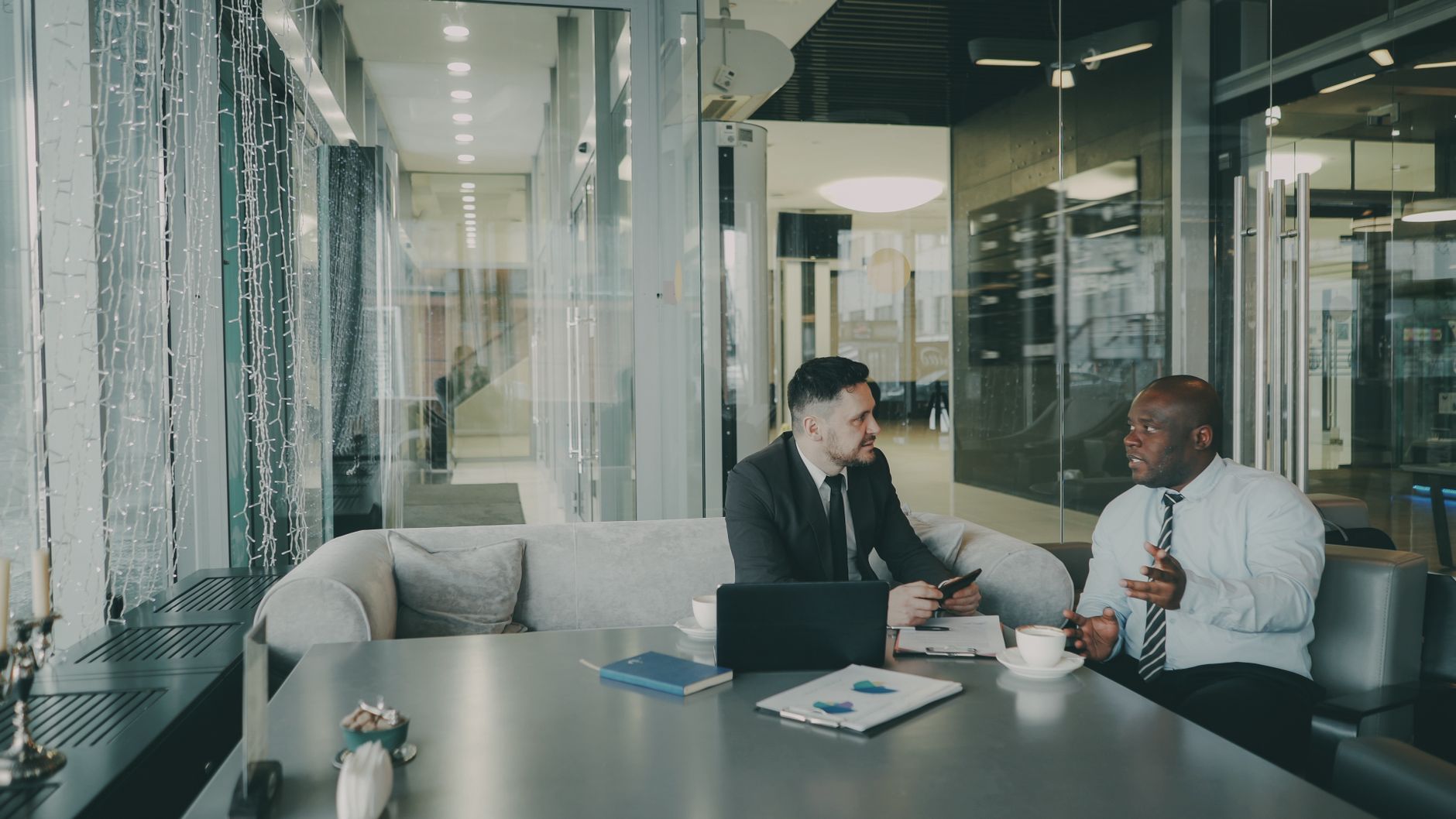 Two businessmen discussing strategy in a contemporary office environment.