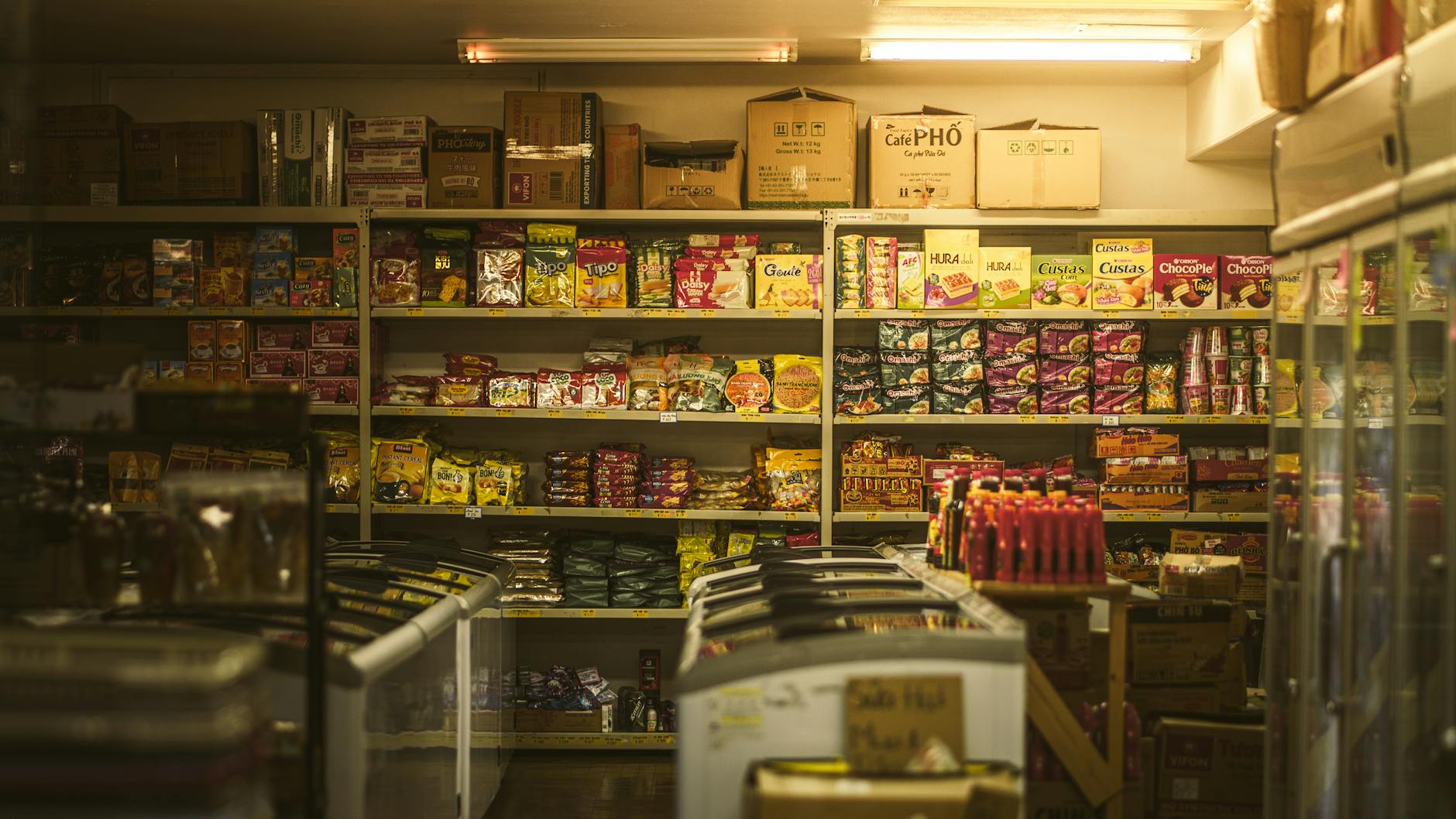 Shelf packed with diverse Asian snacks and groceries in an inviting store setting.
