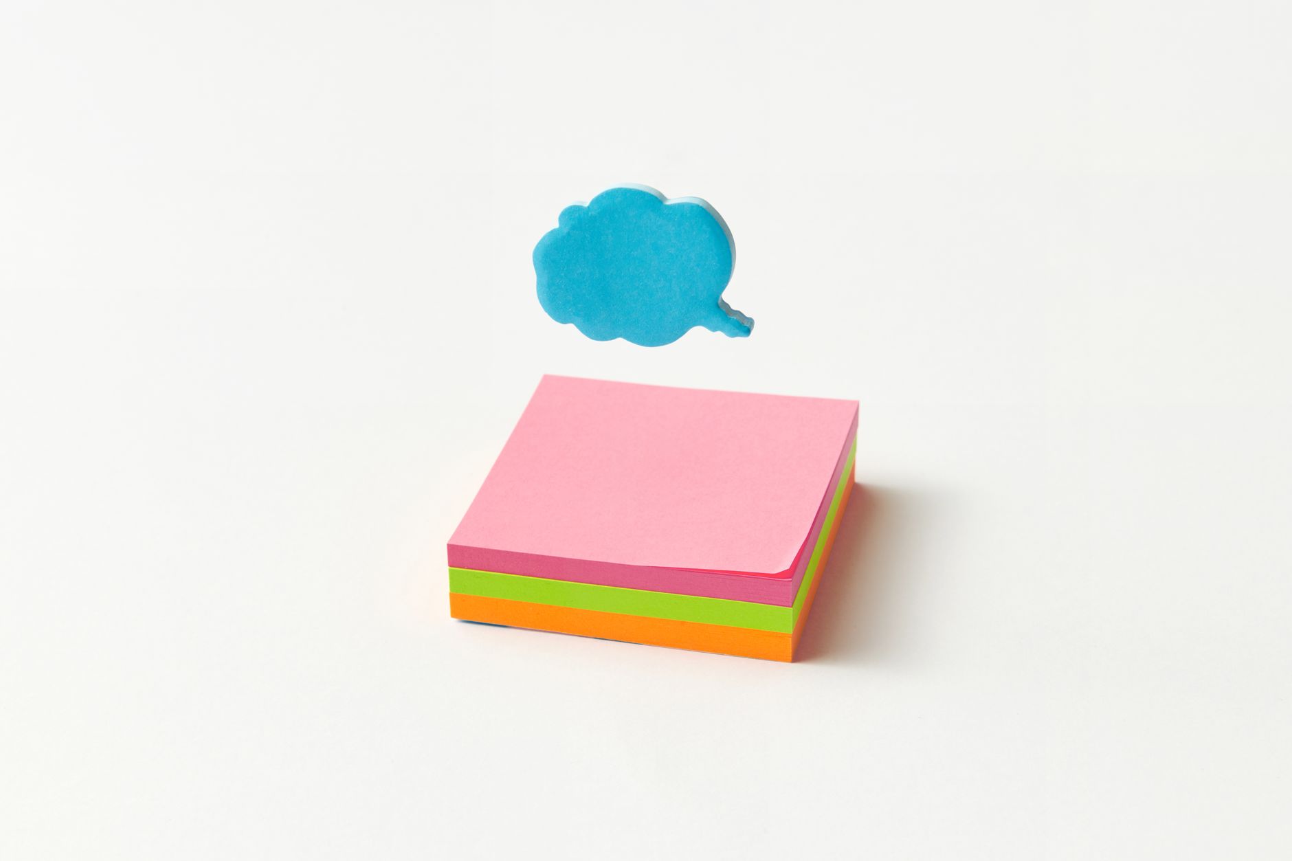 Vibrant stack of sticky notes with a blue cloud-shaped speech bubble on a white background.