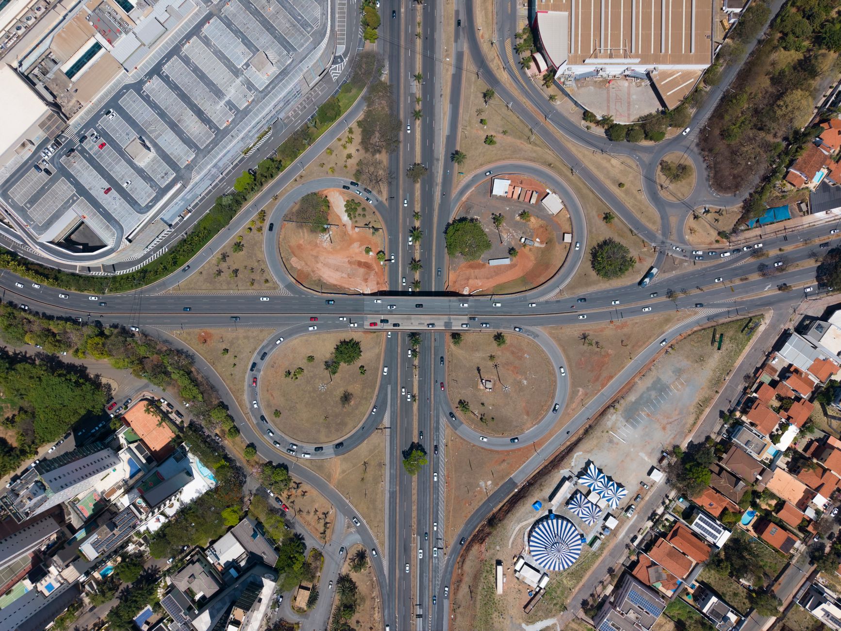 Aerial view of a cloverleaf interchange in Belo Horizonte, Minas Gerais, Brazil, showcasing urban infrastructure and traffic flow.