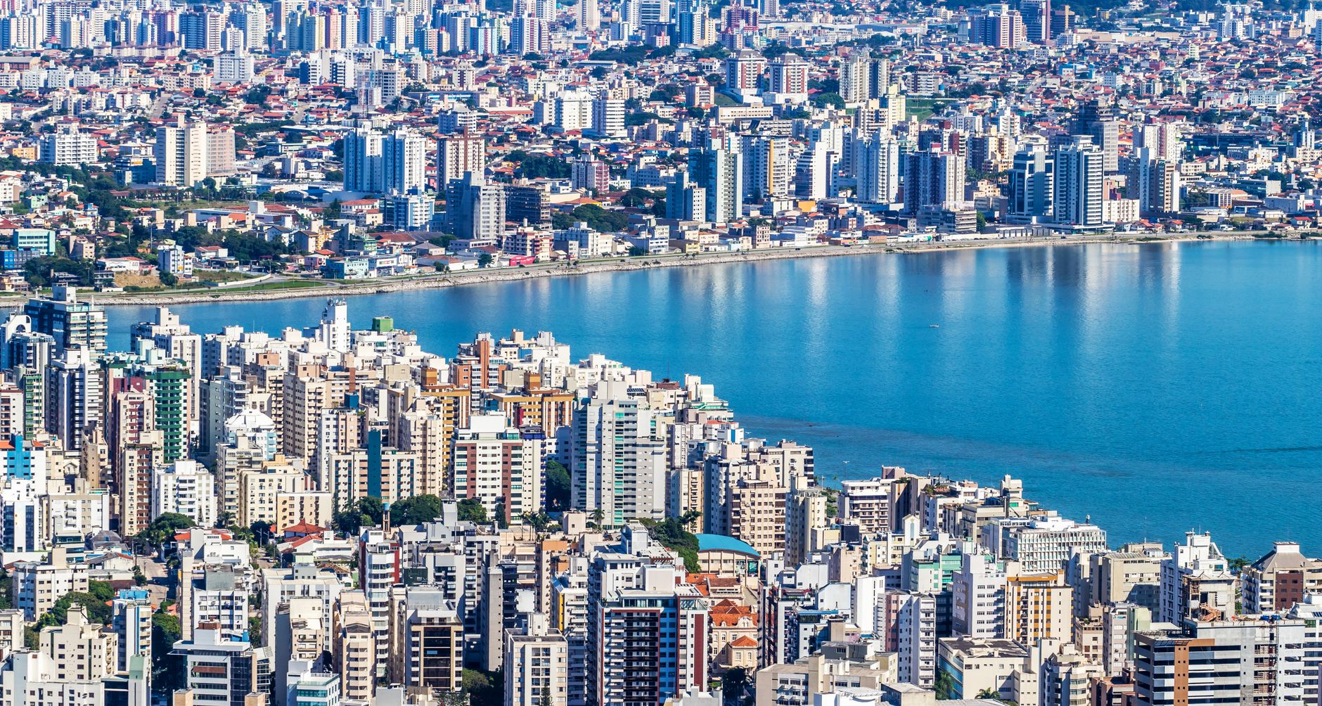 Dynamic aerial view of Florianópolis, Brazil showcasing urban waterfront and vibrant cityscape.