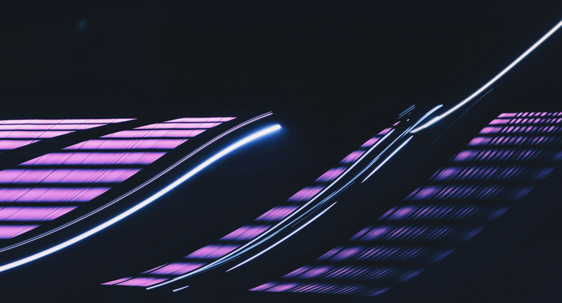 Vibrant abstract image of neon light trails against a dark background.