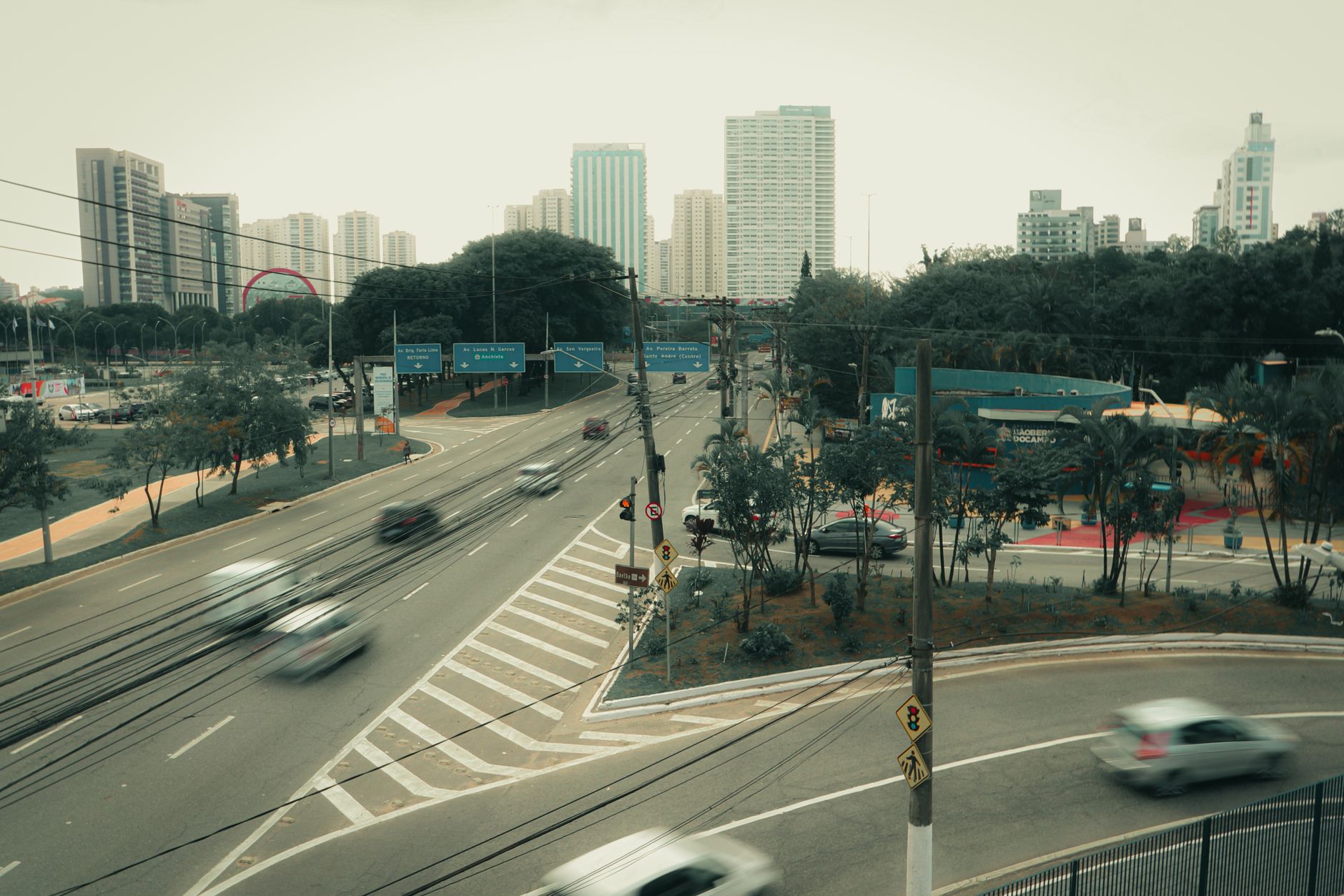 Cityscape of São Bernardo do Campo, Brazil, featuring a busy intersection with skyscrapers and blurred vehicles.