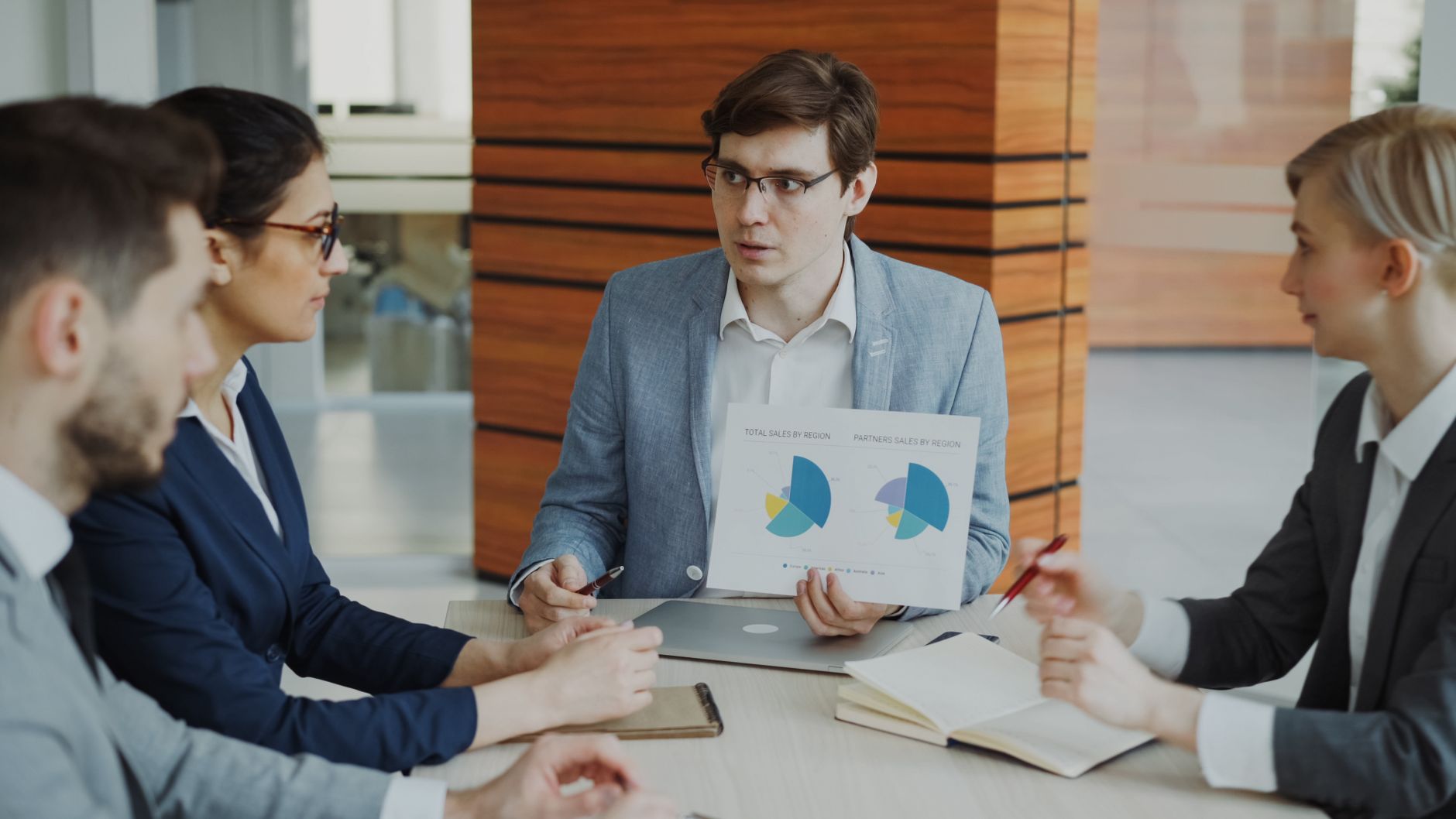 A team engaged in a business meeting discussing charts and strategies in an office.