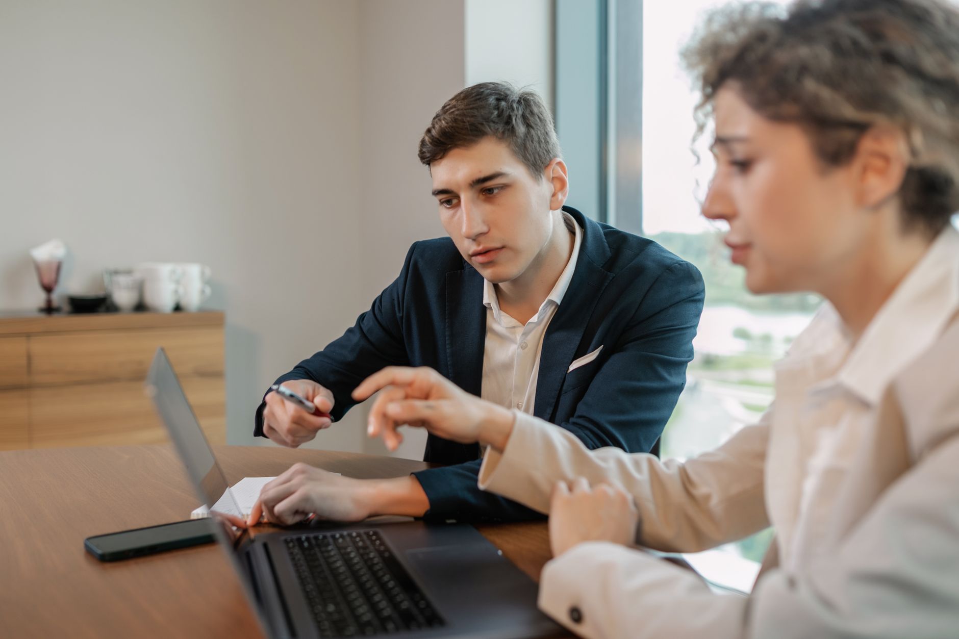 Professional businesspeople discussing work at a modern office table.
