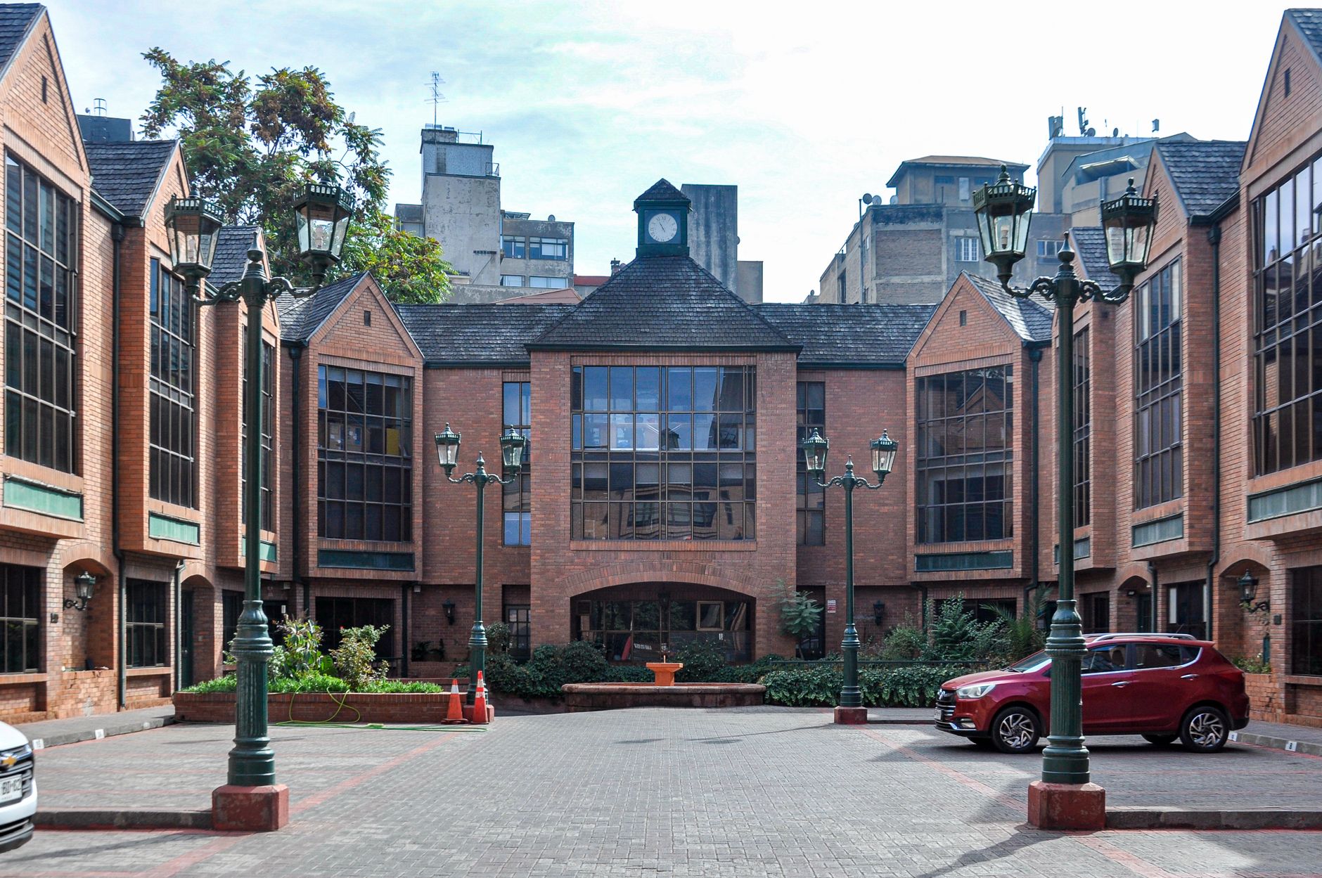 Elegant brick building with courtyard, vintage lamps, and classic architectural style in Santiago, Chile.