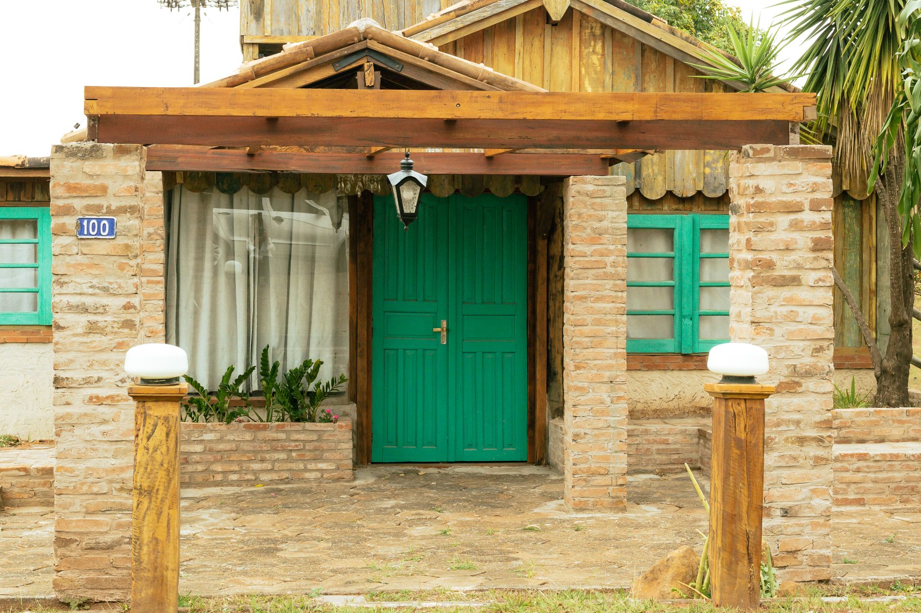 Rustic wood house with green door in São Paulo garden setting. Perfect for nature lovers.