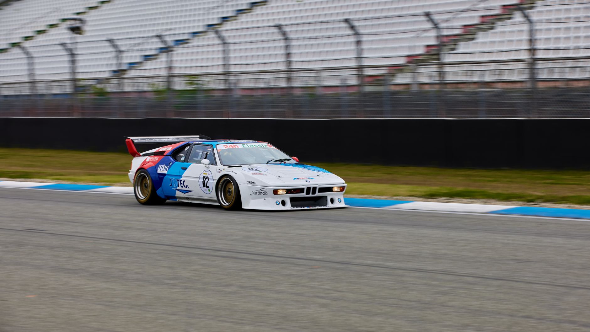 Classic BMW racing car speeding on a racetrack, showcasing motorsport enthusiasm.