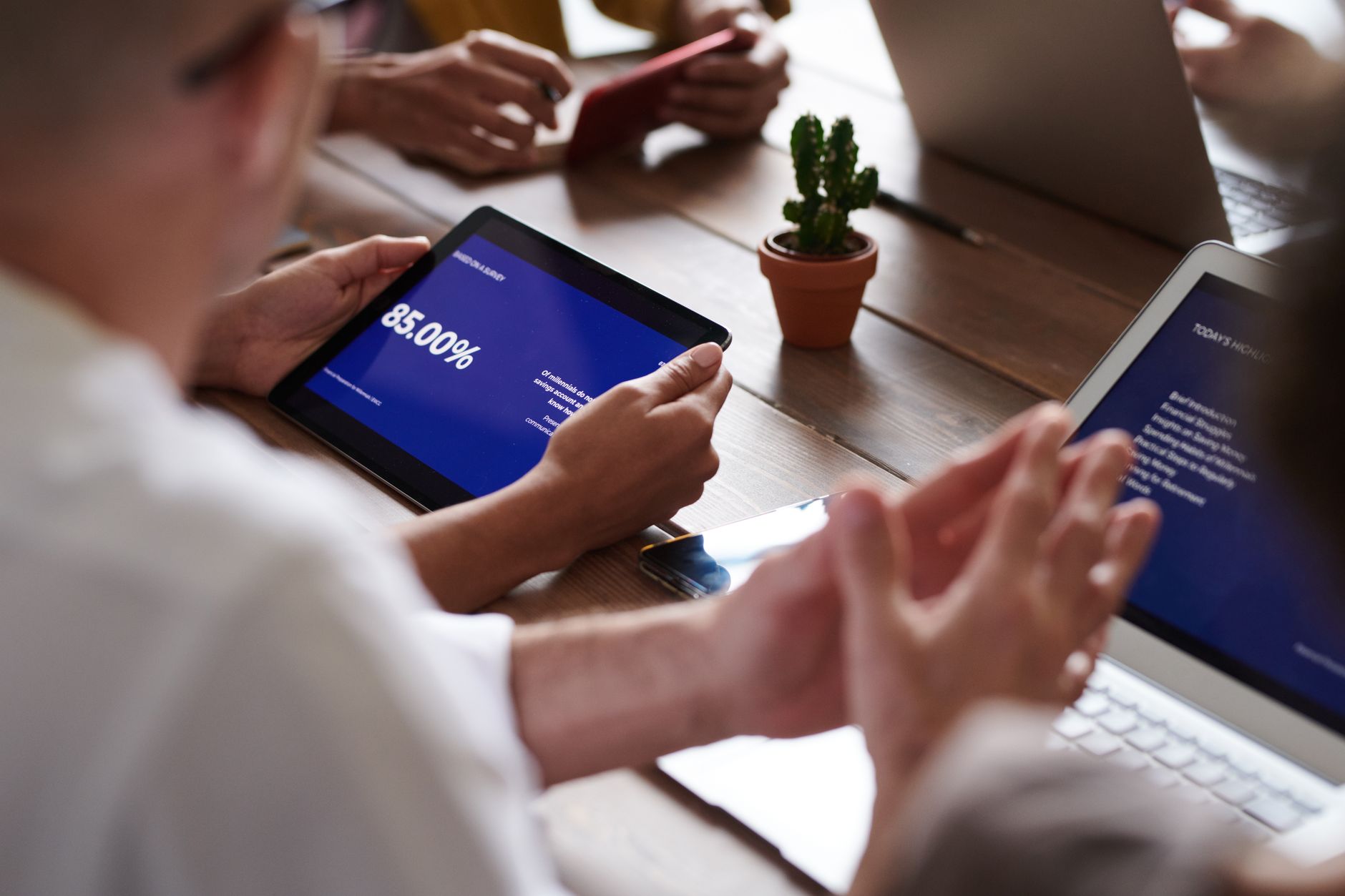 Business meeting with tablets and laptops. Focus on presentation on tablet screen.