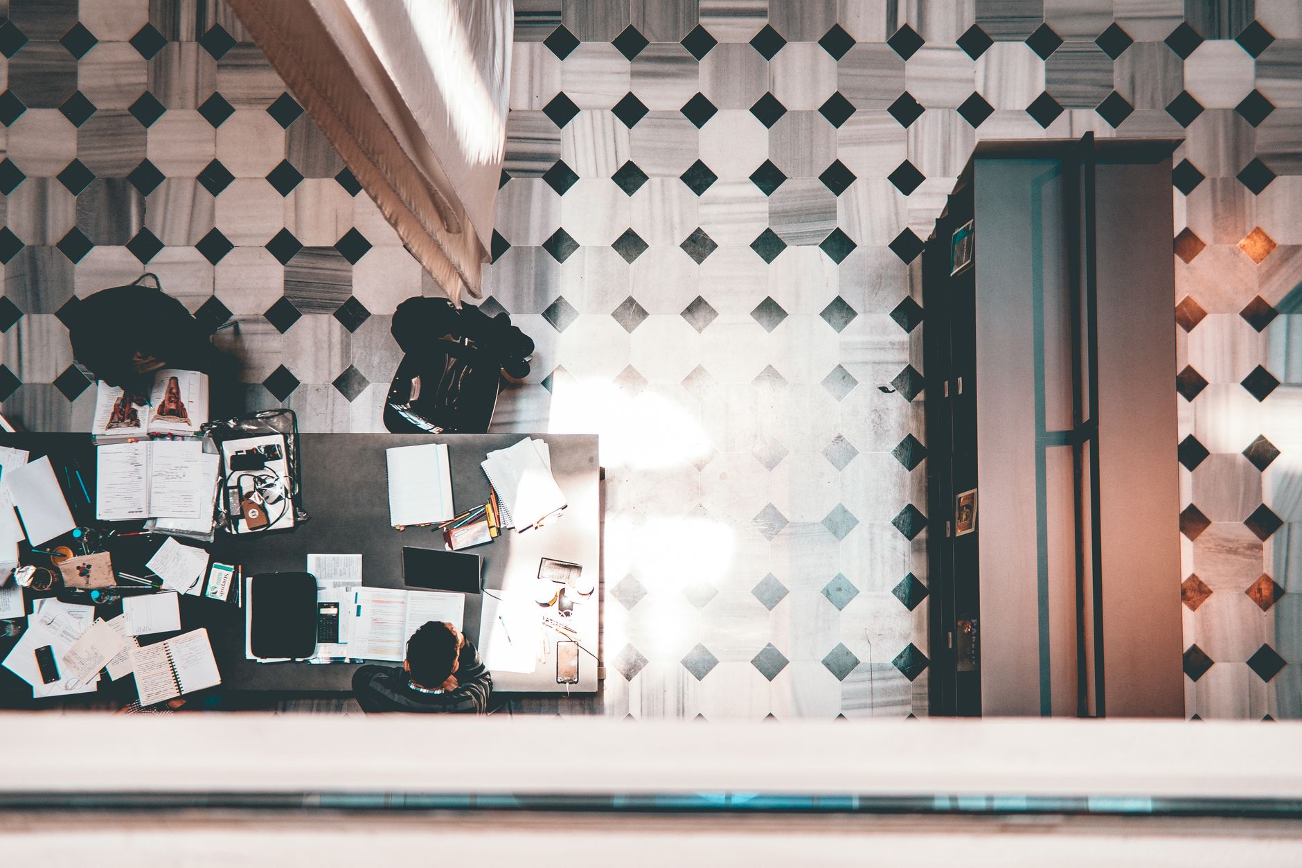 High-angle shot of a modern workspace with people and geometric patterned floor.