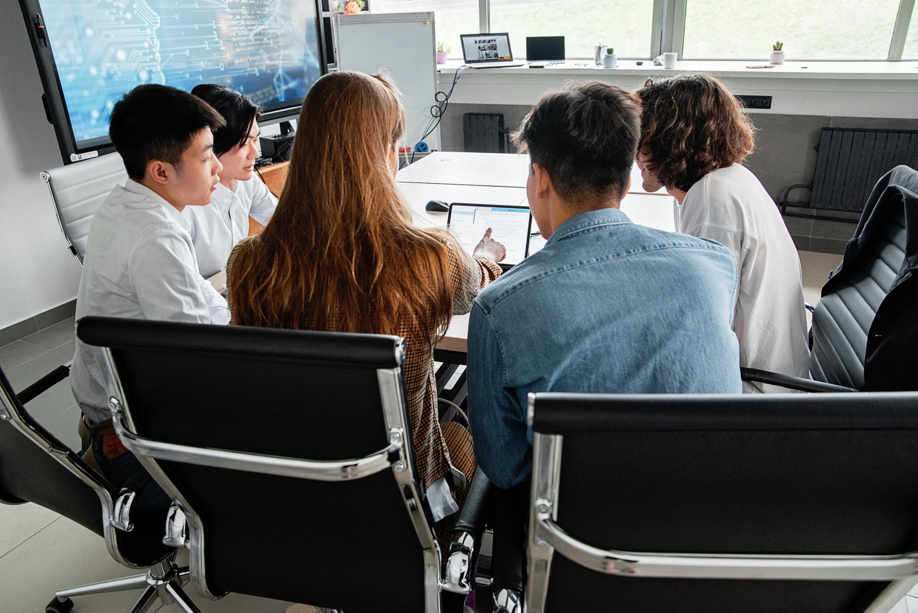 A team engaged in a collaborative meeting around a table in a modern office setting.