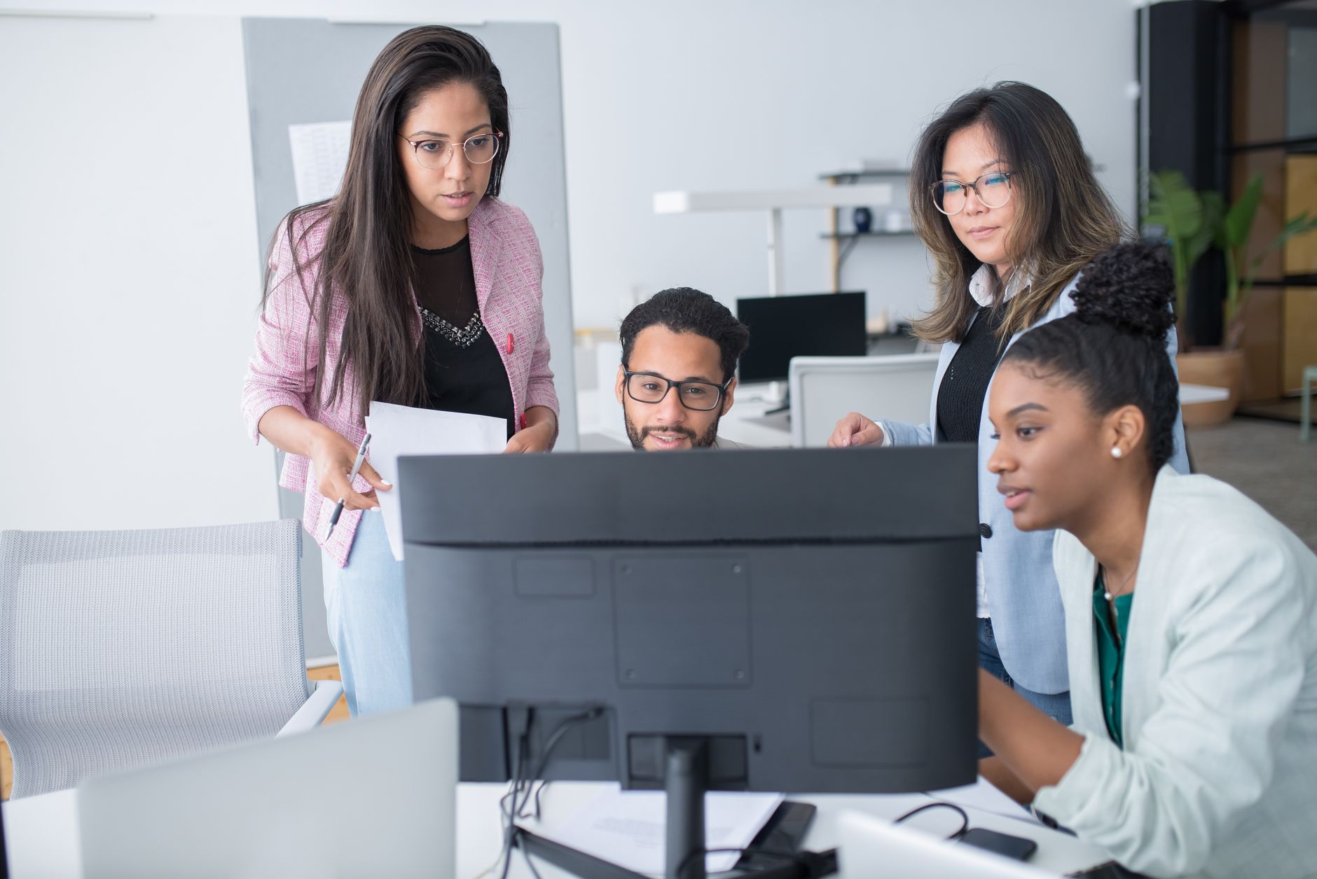 A diverse team of professionals collaborating on a project in a modern office environment.