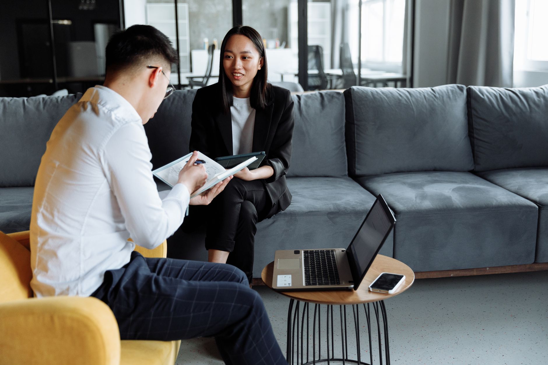 Two professionals collaborating in a modern office setting, discussing ideas with technology.