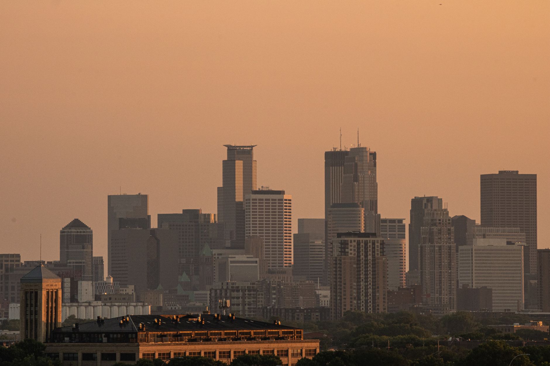 A stunning cityscape silhouette against a golden sunset, showcasing skyscrapers in a metropolitan skyline.