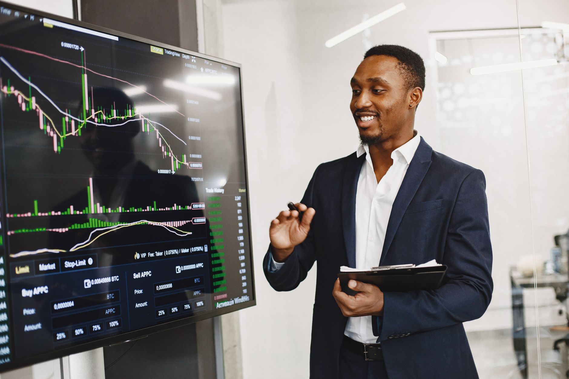 Professional man presenting financial data on a digital screen in modern office.