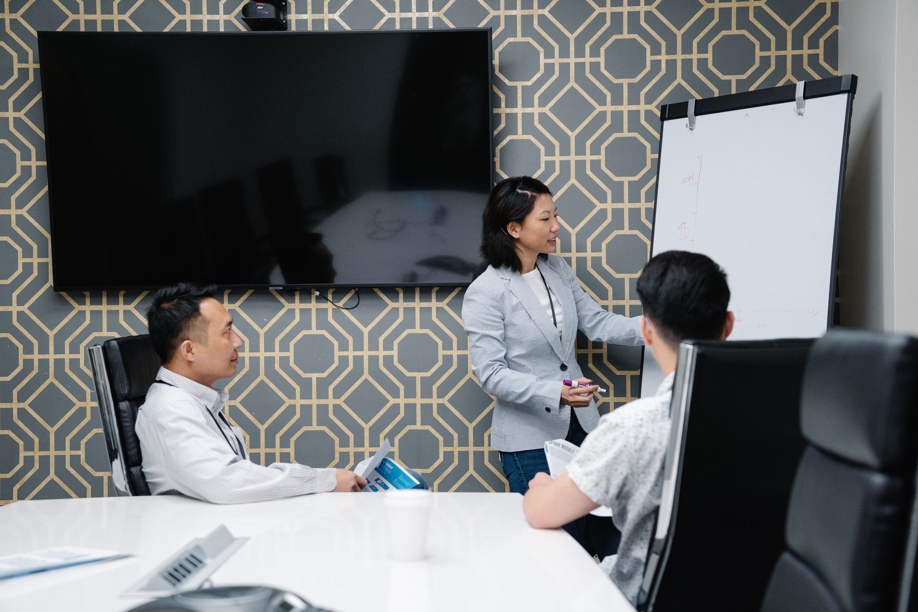 A professional conducting a presentation in a modern office space with colleagues engaged.