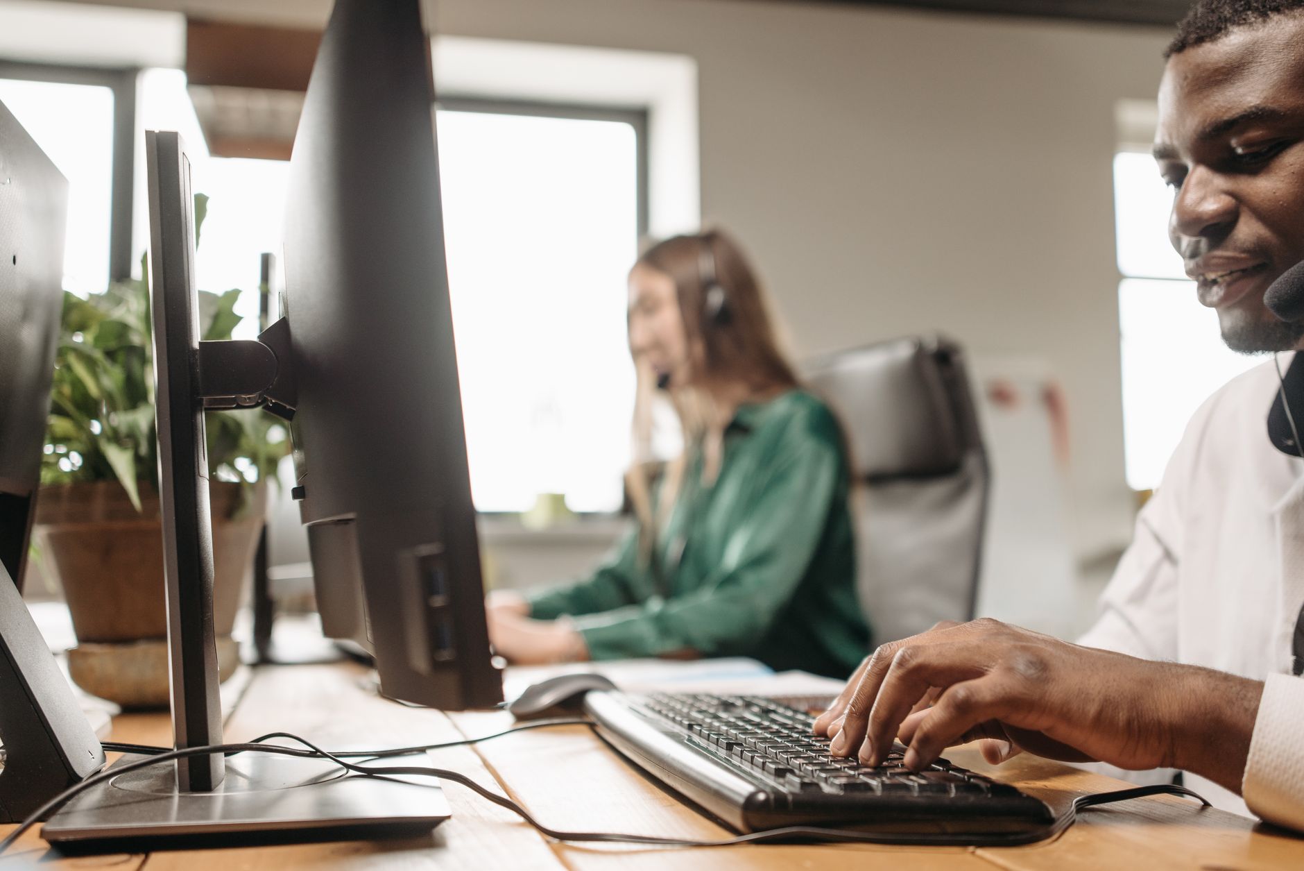 Customer support agents working at a busy call center with focus on diversity and teamwork.