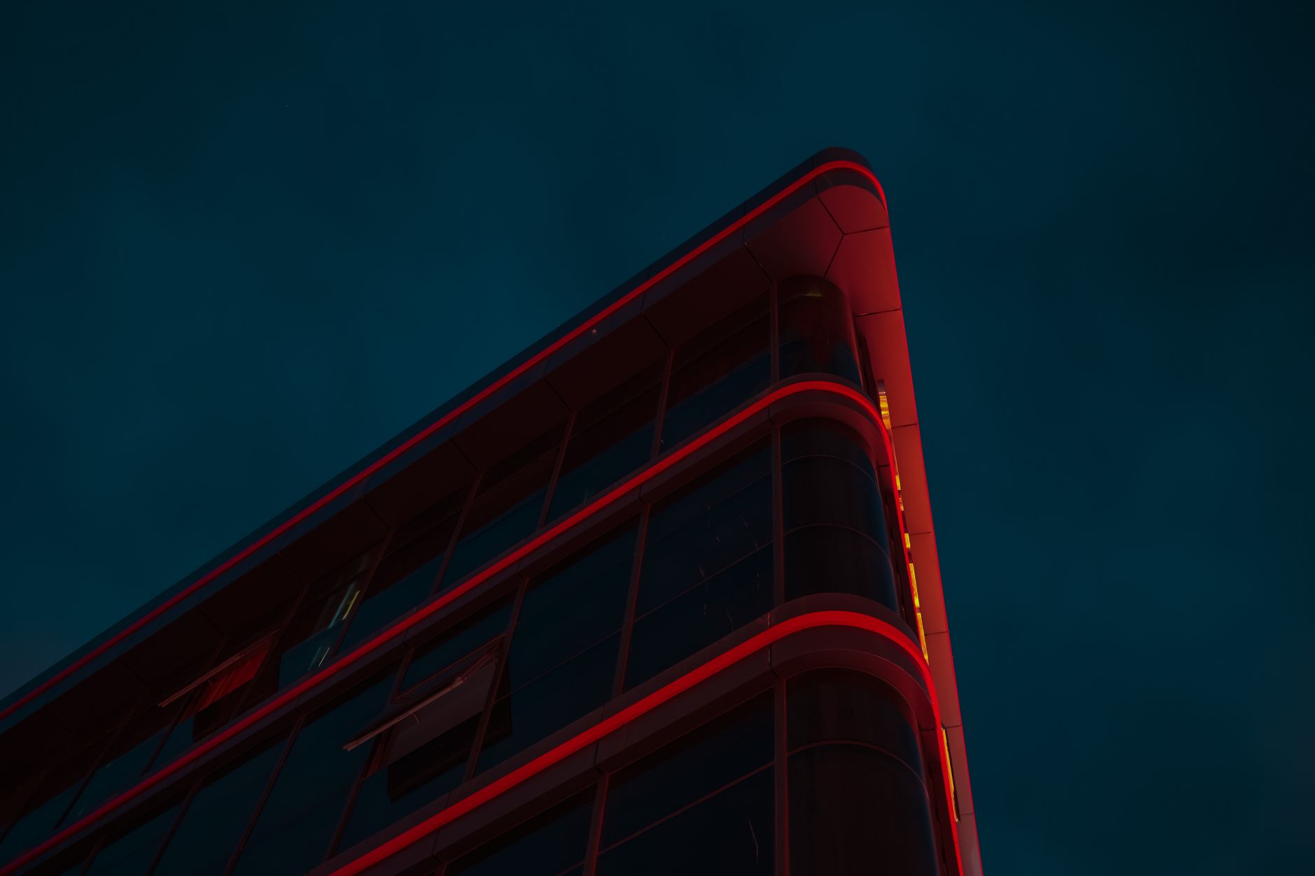 A dramatic view of a modern building with red lighting against a night sky, captured in Güzelyurt.