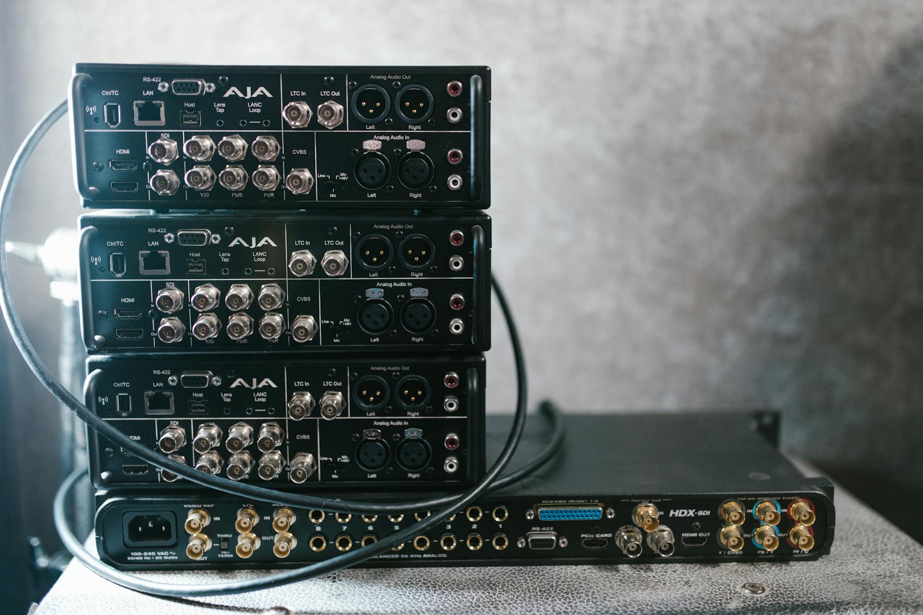 Stacked professional audio video equipment with multiple connectors for recording studio settings.