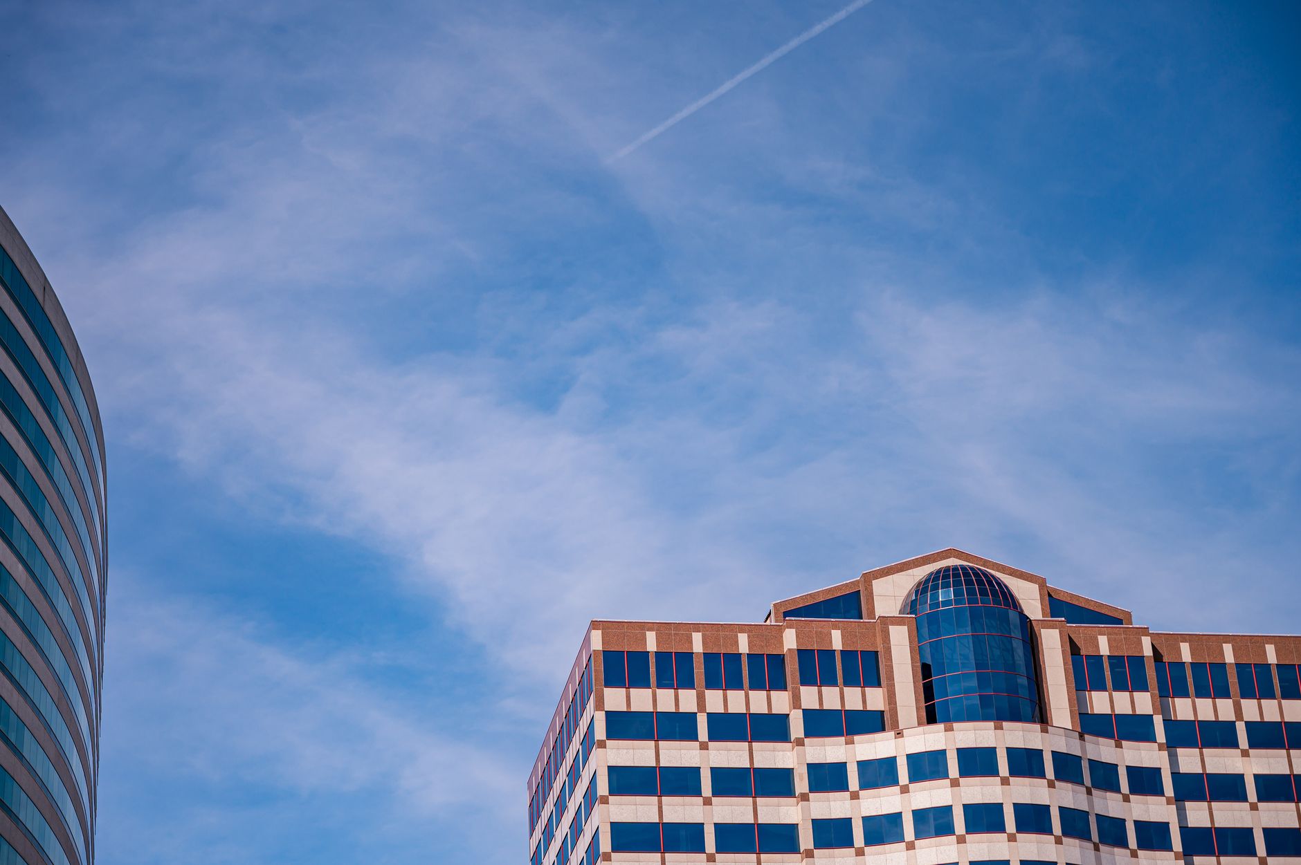 A striking view of modern skyscrapers under a clear blue sky, showcasing architectural design.