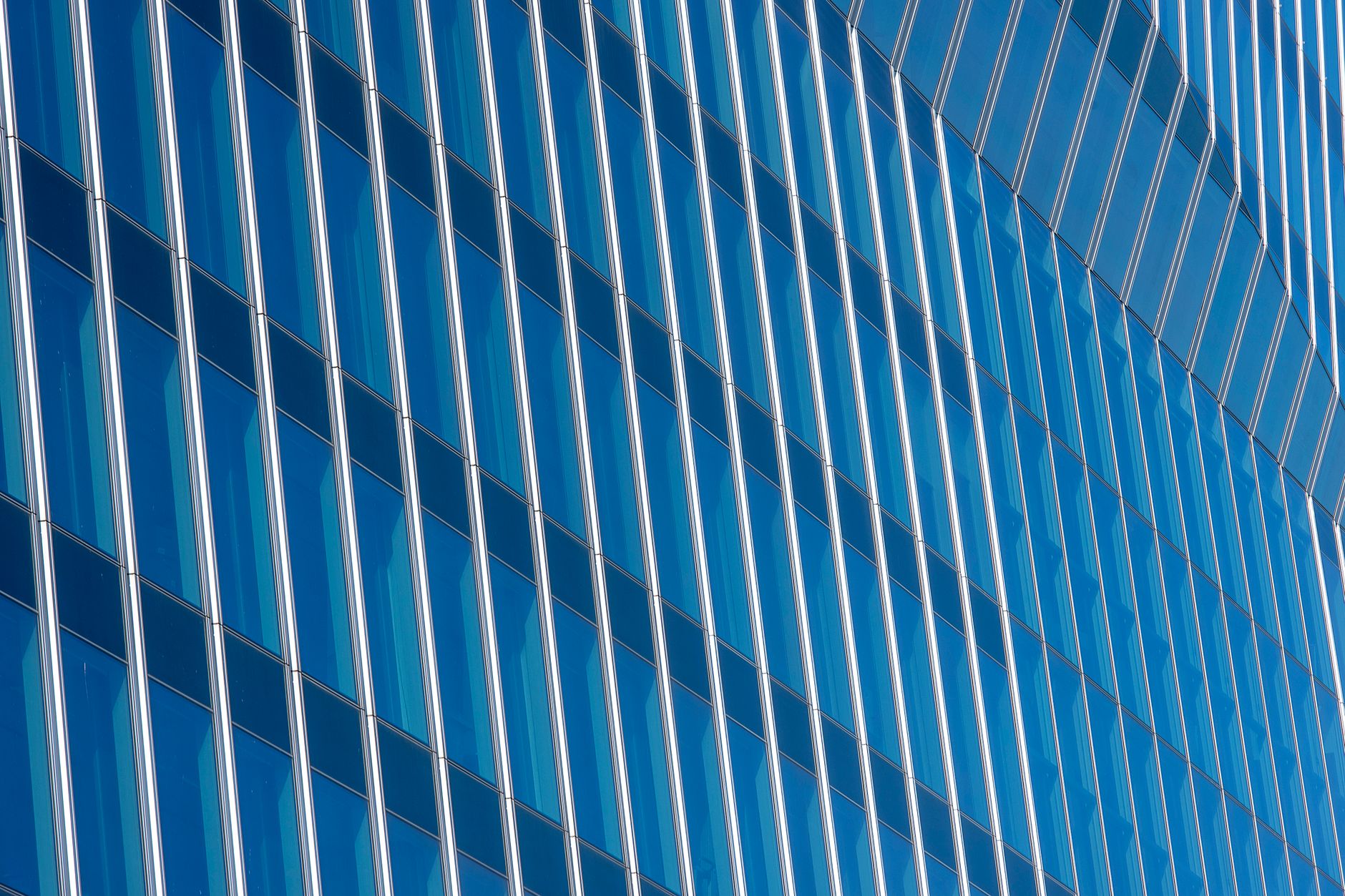Close-up shot of a modern skyscraper's glass facade with reflections.
