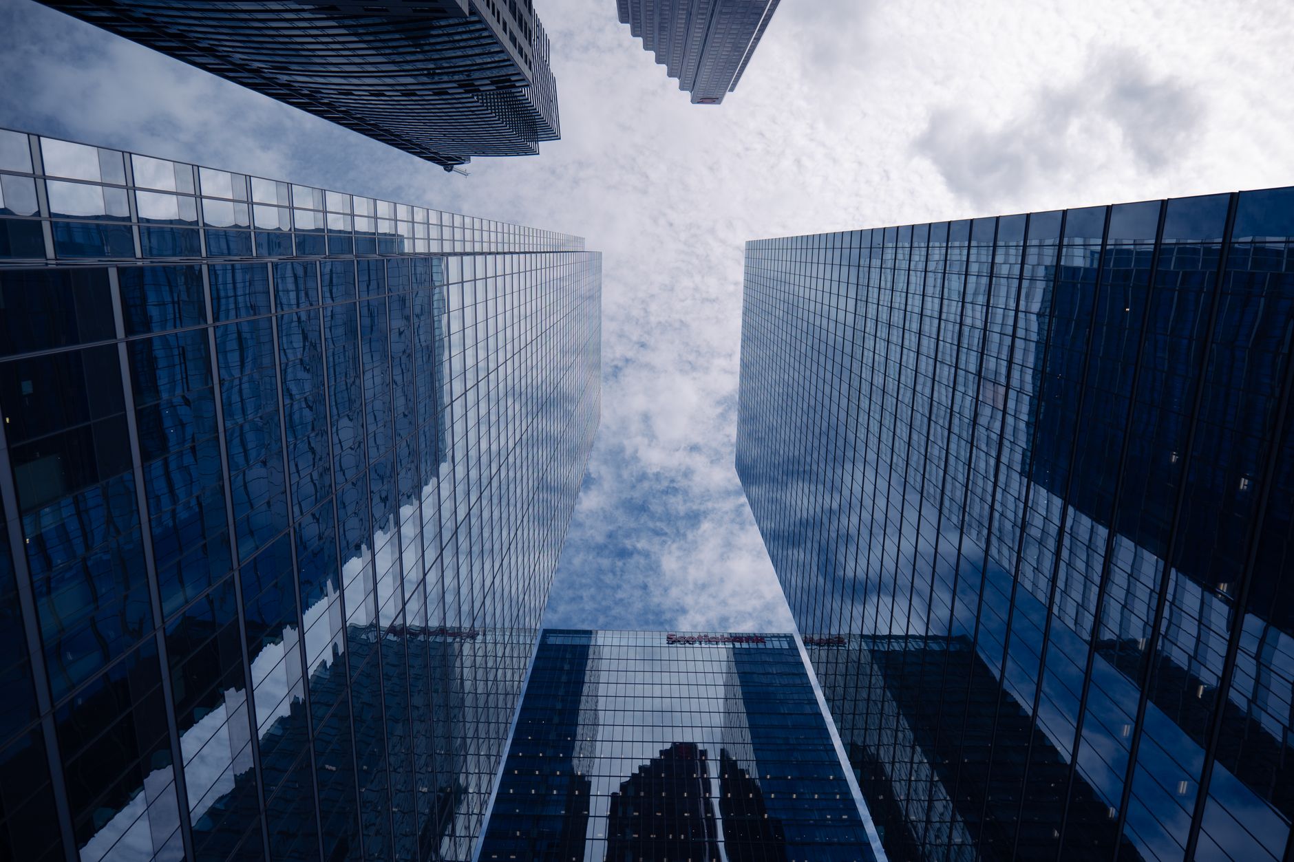 Contemporary skyscrapers in Toronto showcasing sleek glass architecture and reflecting the vibrant city sky.