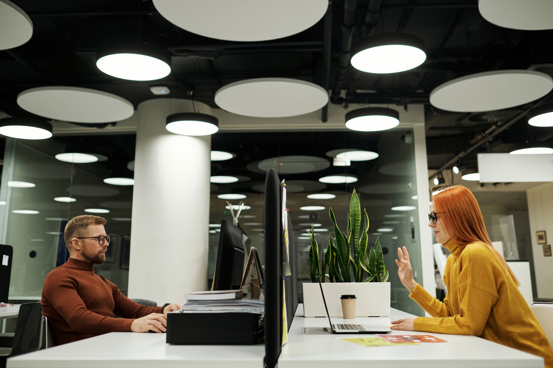 Two colleagues collaborating in a contemporary office space with sleek design elements.