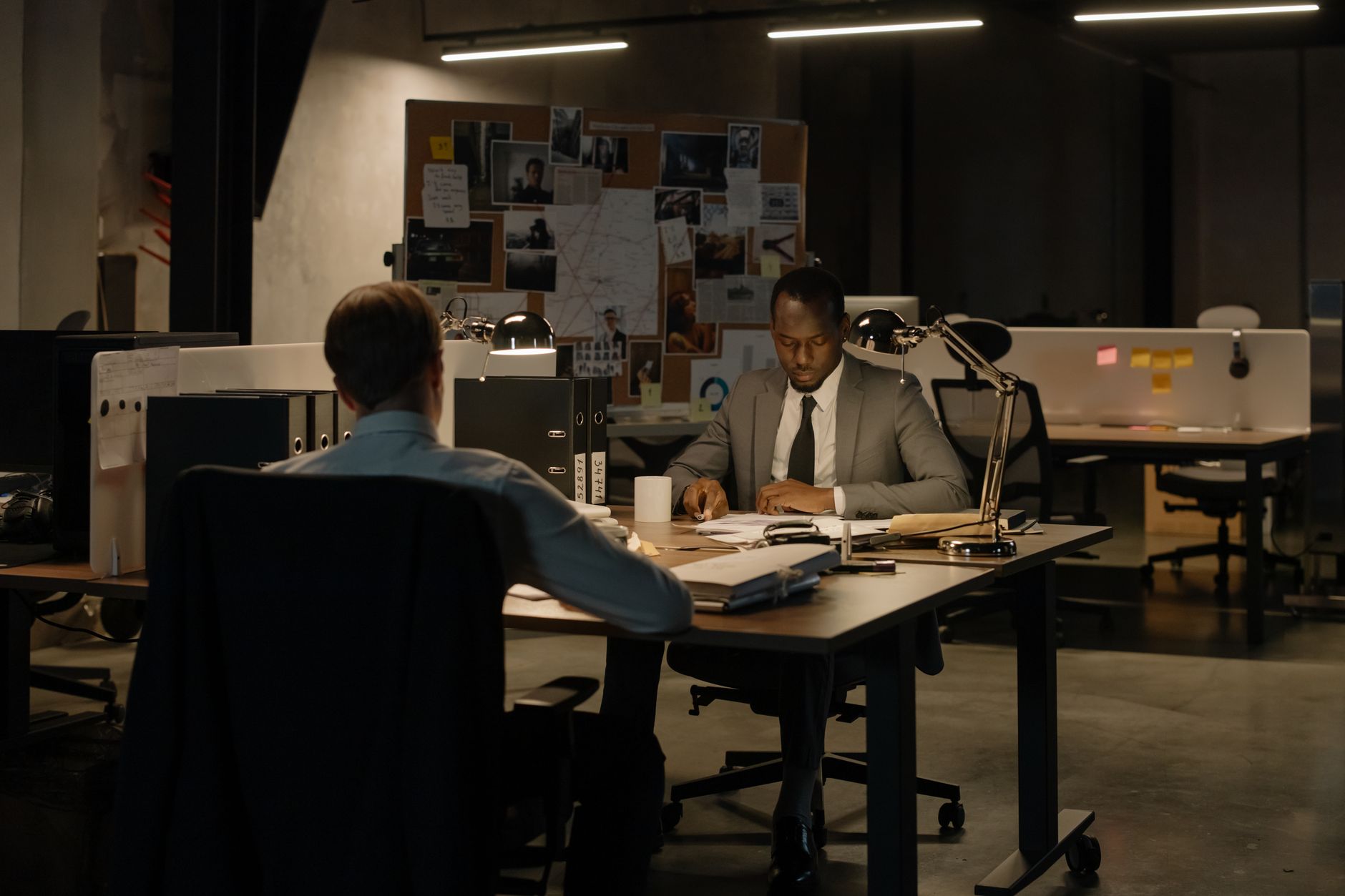 Two men in an office setting working together late at night on a project.