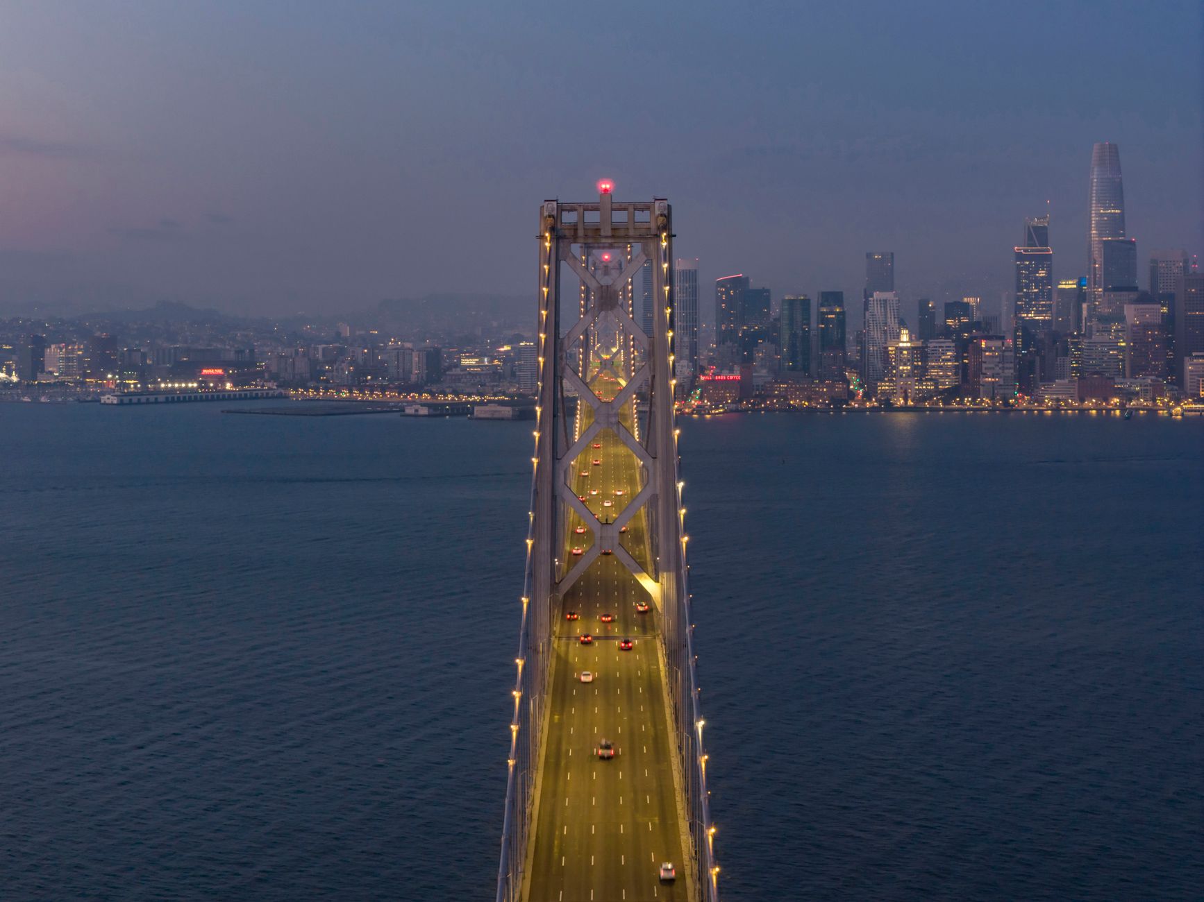 A stunning aerial shot of the Bay Bridge in San Francisco at dusk with city skyline in the background.
