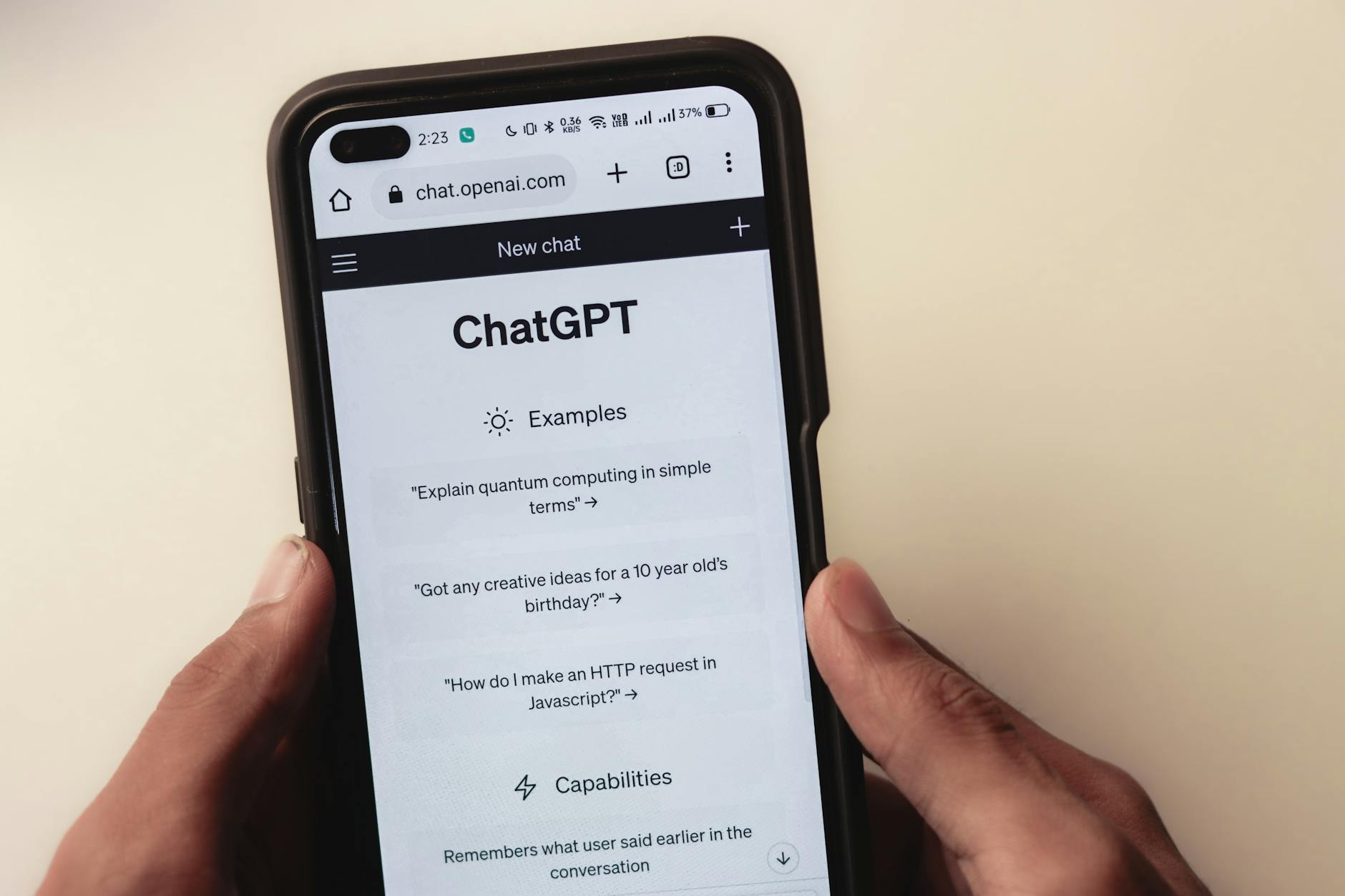 Hand holding a smartphone with AI chatbot app, emphasizing artificial intelligence and technology.