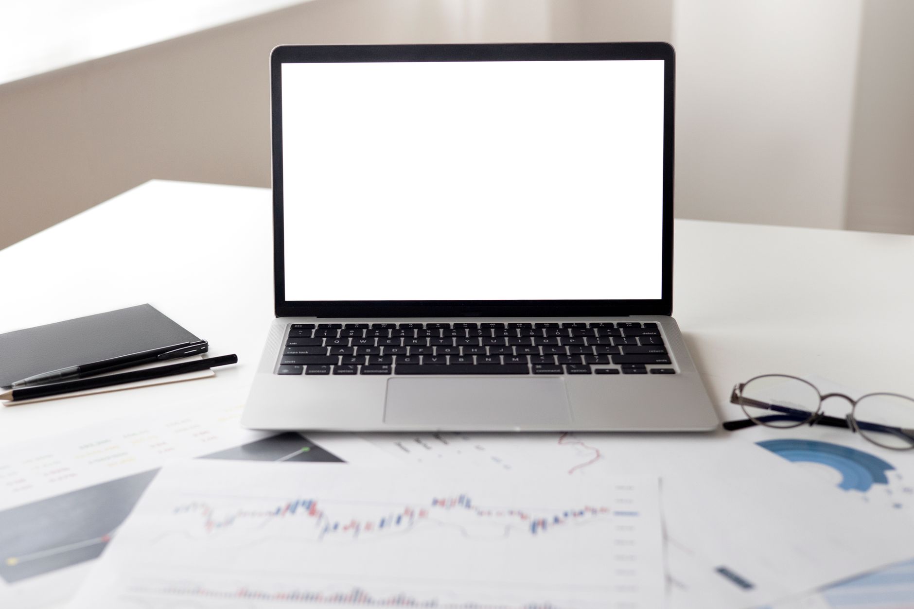 Open laptop with financial documents on a desk, ideal for business and technology themes.