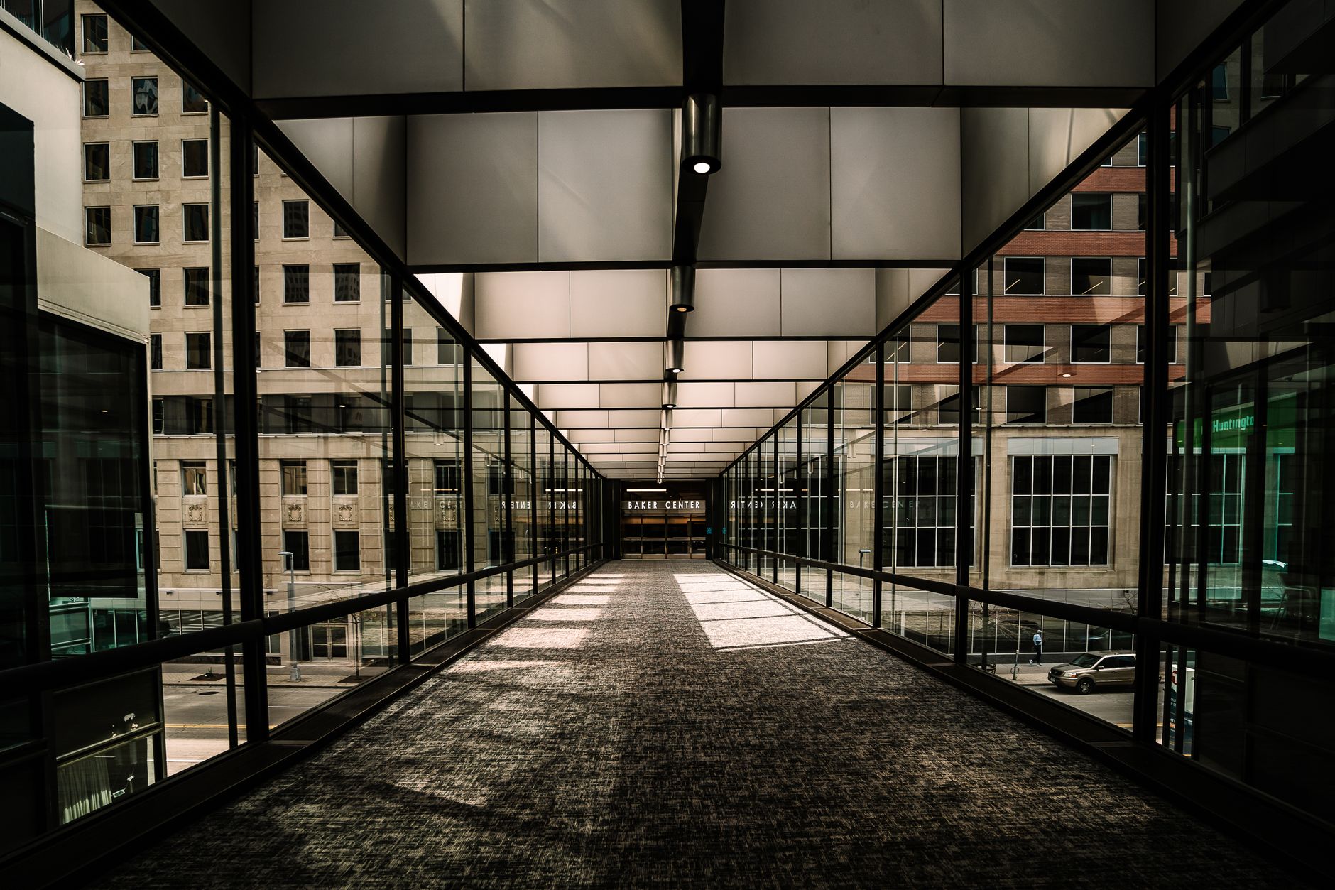 A view of a modern, glass-enclosed skyway in downtown Minneapolis, Minnesota.