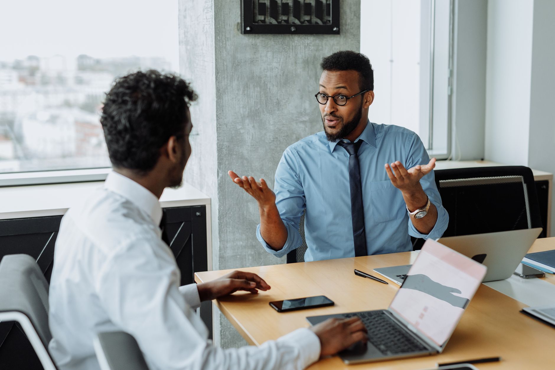 Two male colleagues having a strategic discussion in a modern office setting.