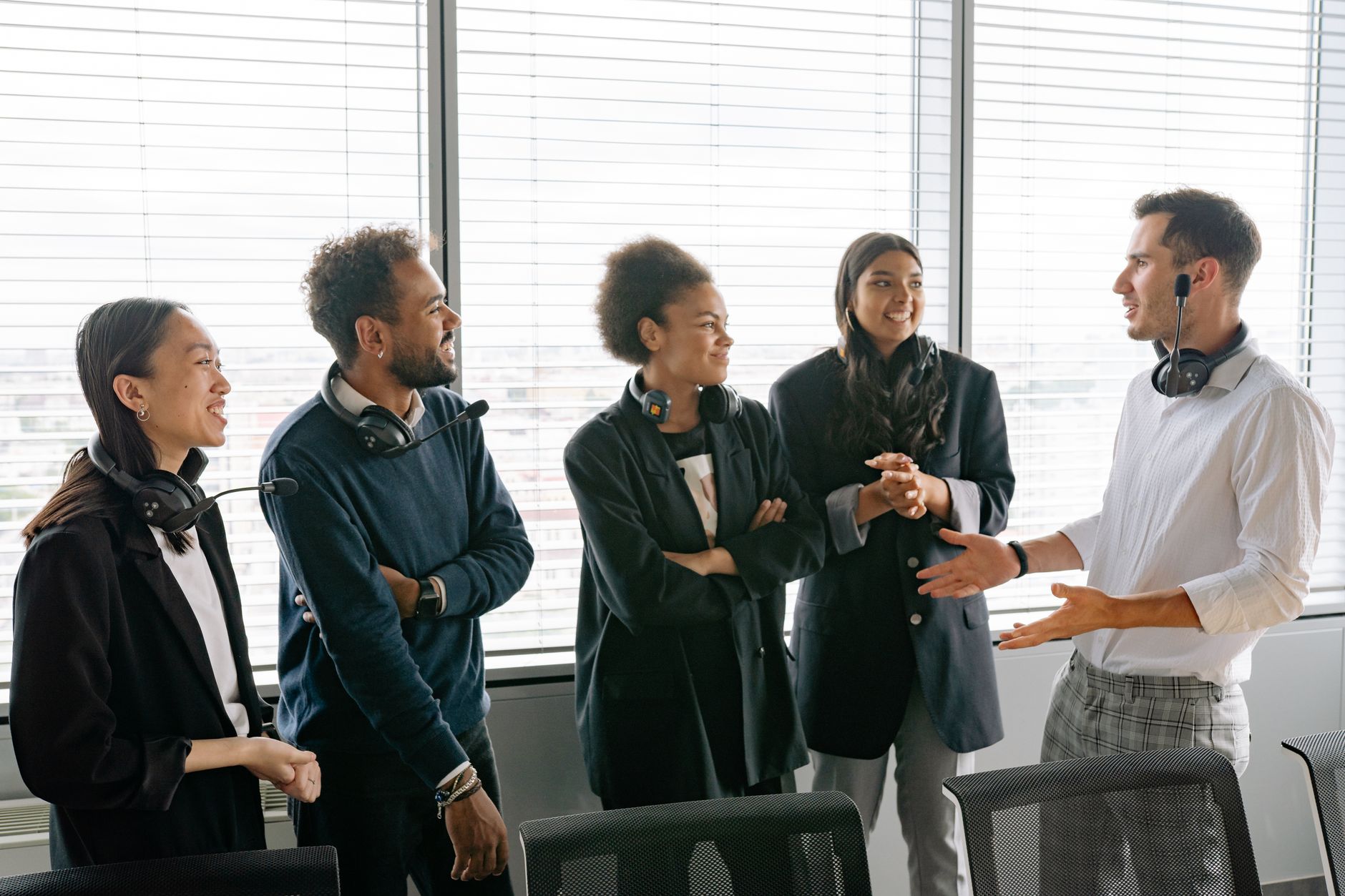 A diverse group of professionals having a conversation in a modern office environment.