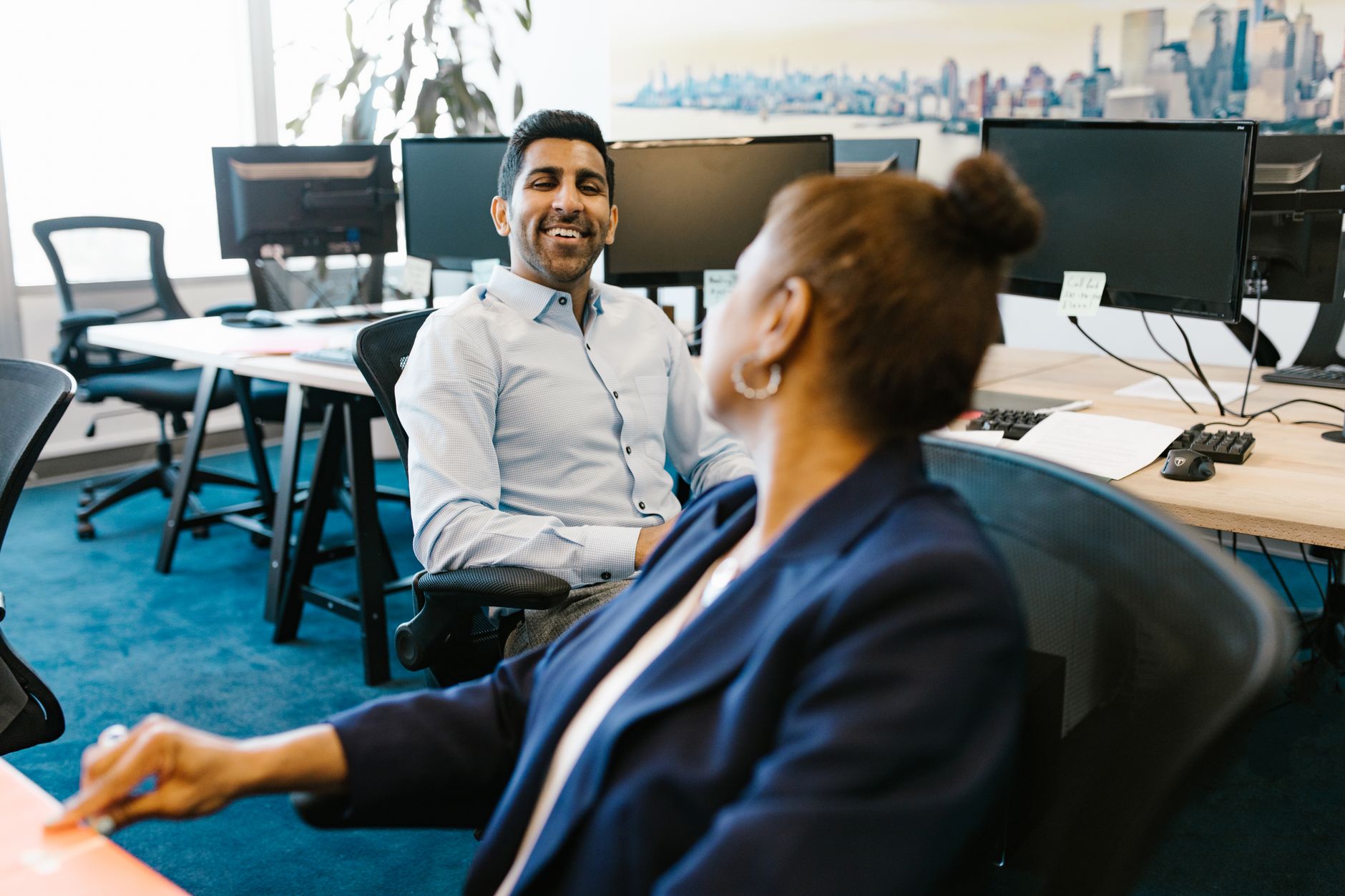 Business professionals engage in discussion at a modern office workplace.