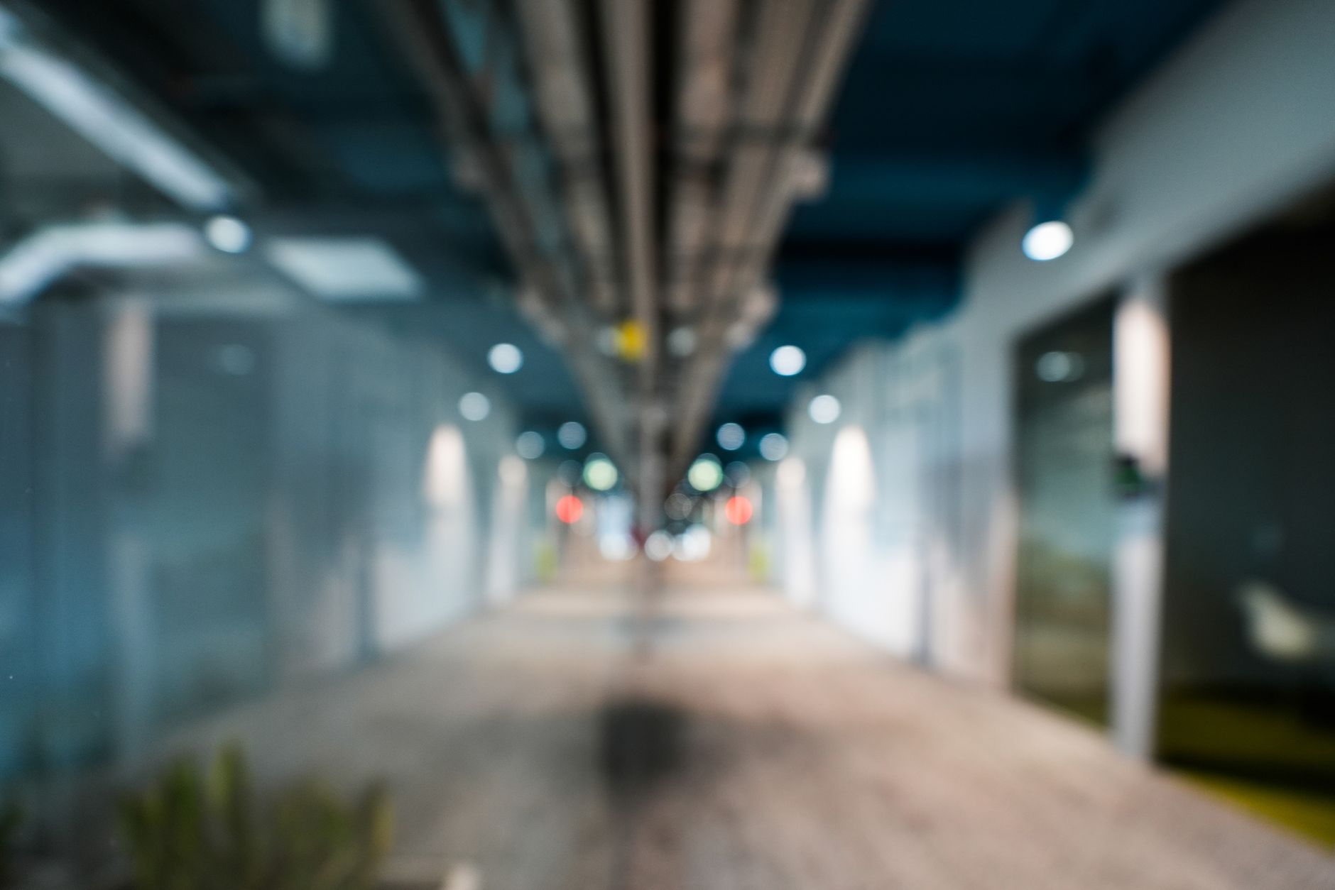 A blurred view of a contemporary office hallway showcasing modern architectural design and lighting.
