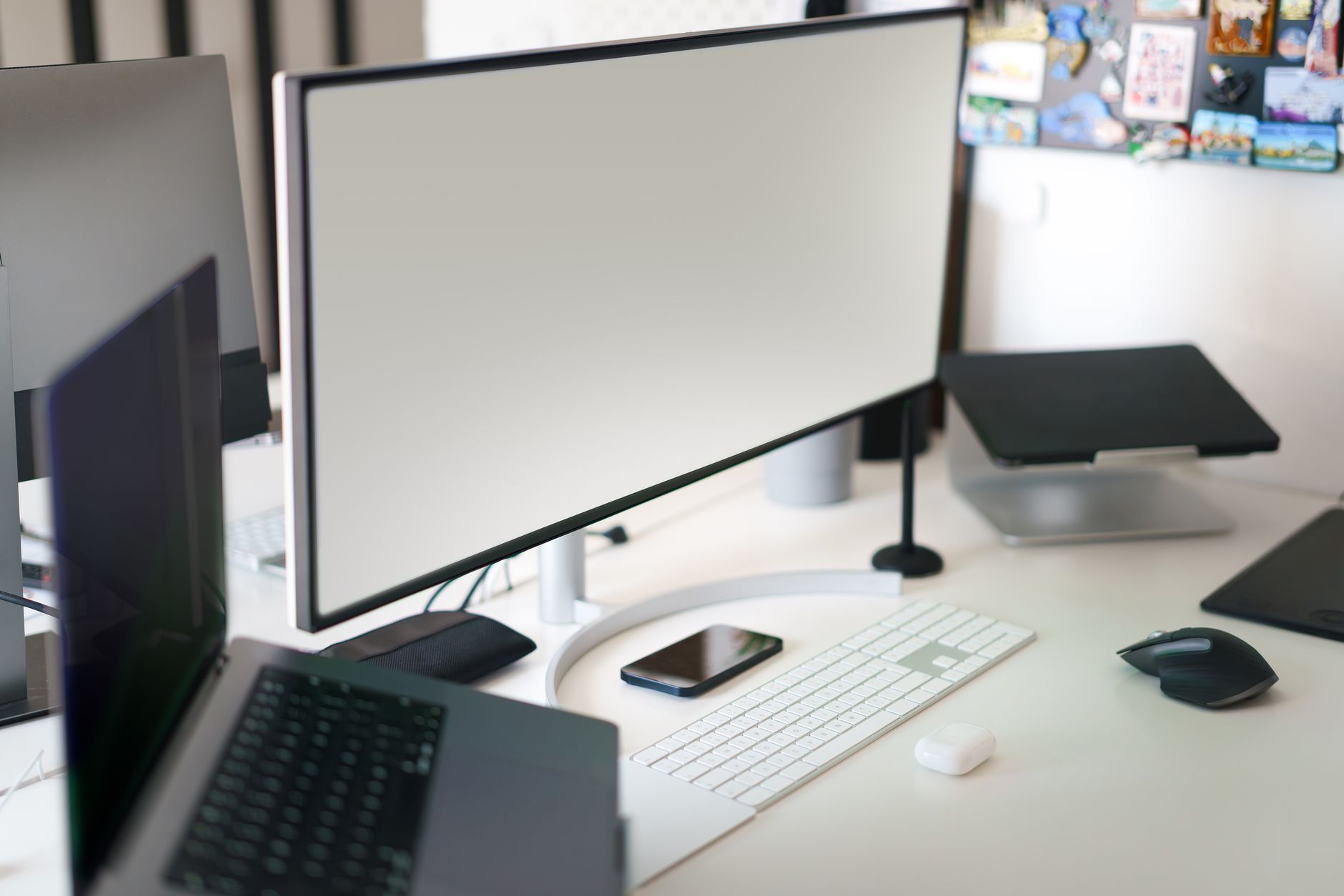 Clean and modern office workspace featuring a desktop setup with a large monitor and accessories.