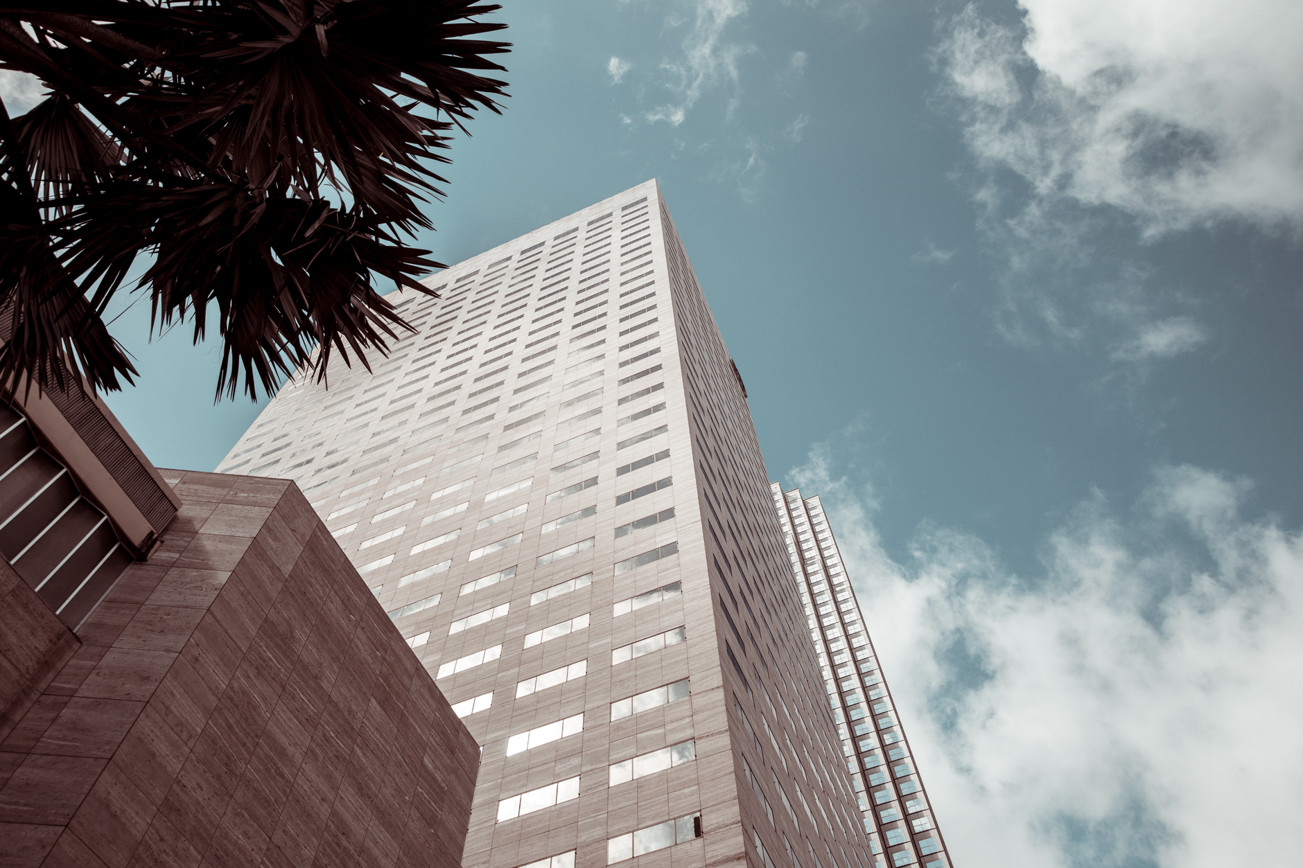 Tall modern building with glass windows against a blue sky in Miami.