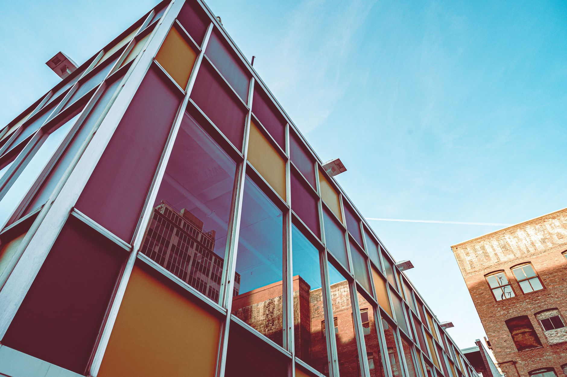 Low angle view of a modern colorful building reflecting the urban skyline.