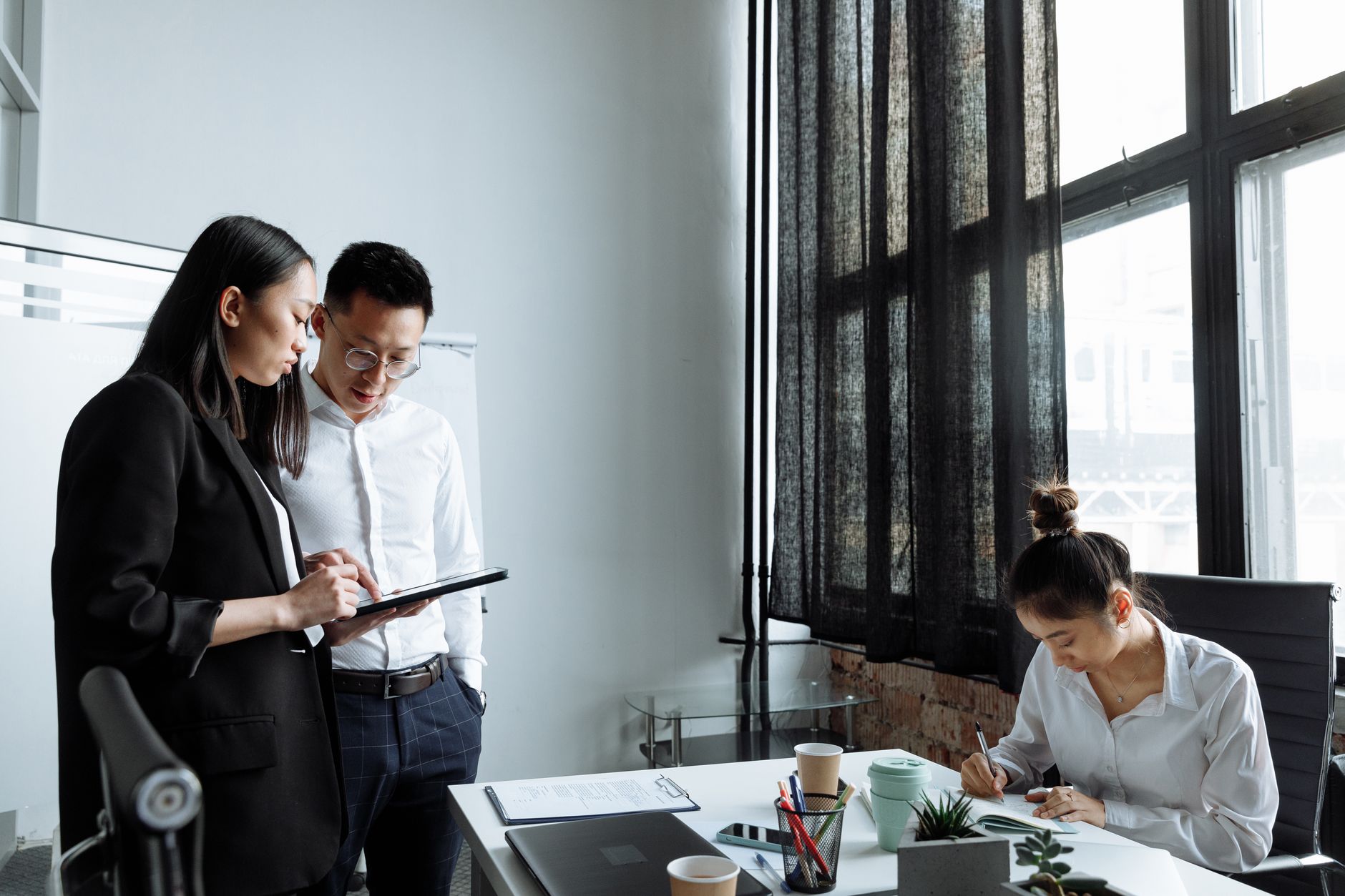 Professionals collaborating in a modern office environment, focusing on planning and teamwork.