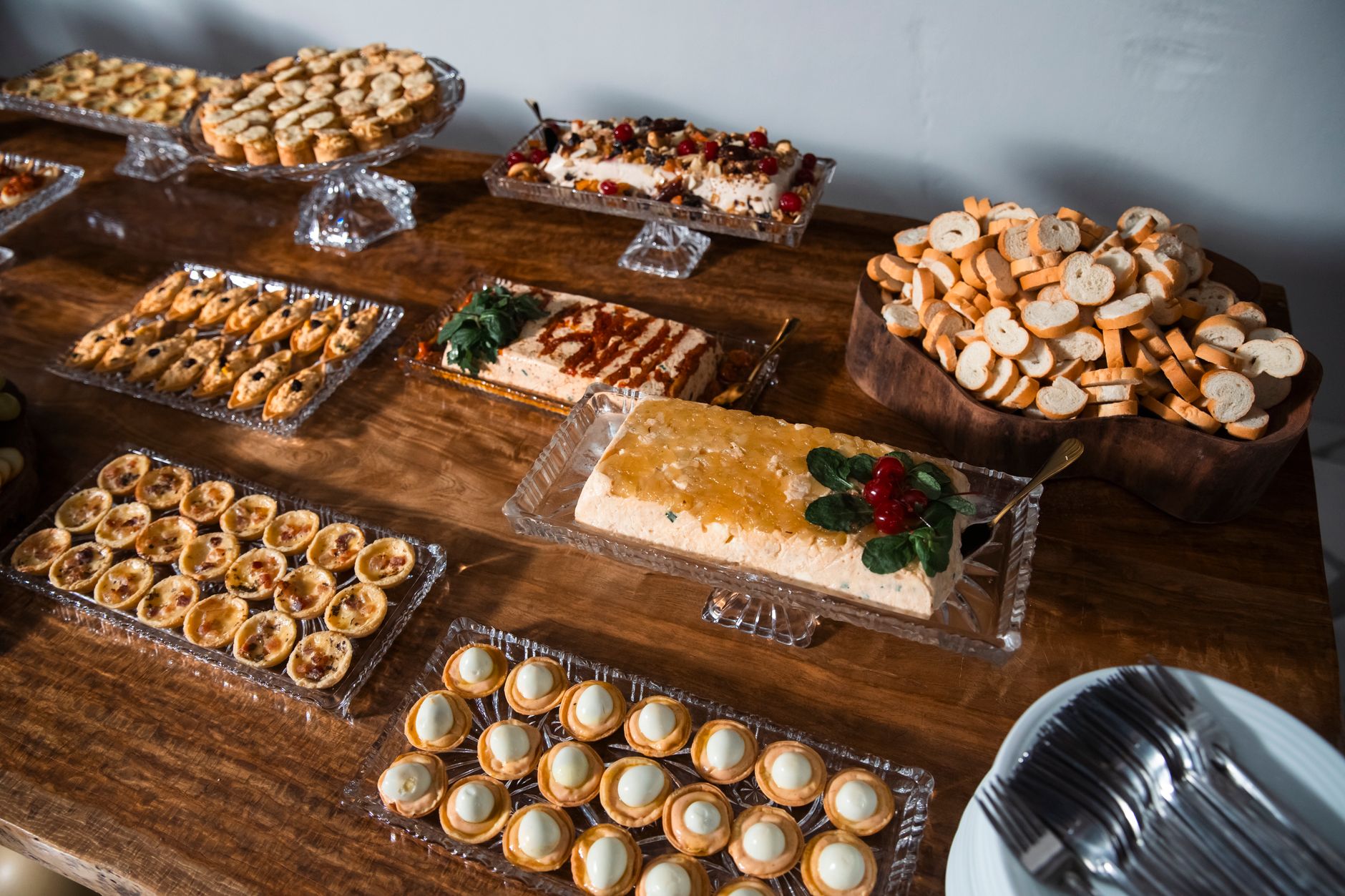 A luxurious display of assorted sweet and savory desserts and pastries on a wooden table.