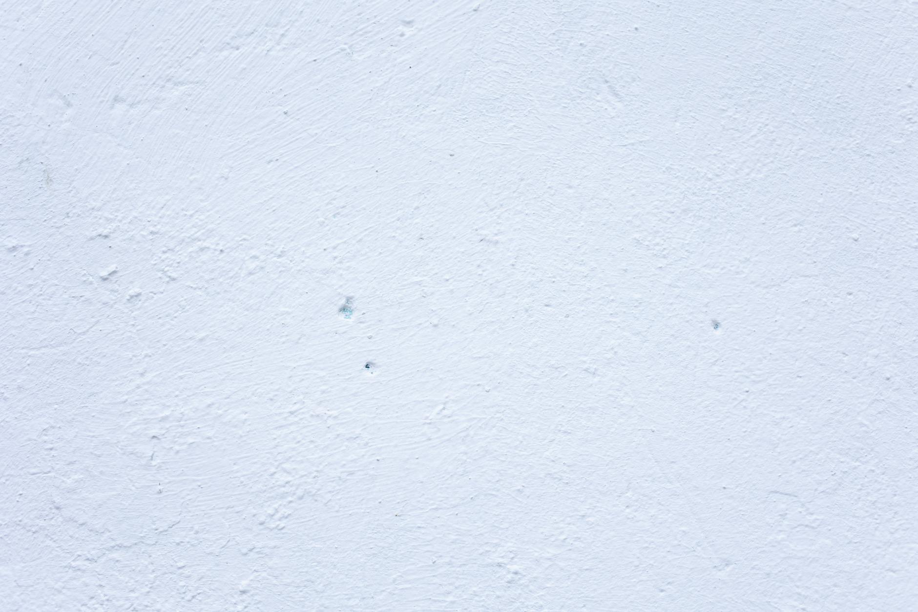A textured white wall perfect for use as a minimal and clean background.