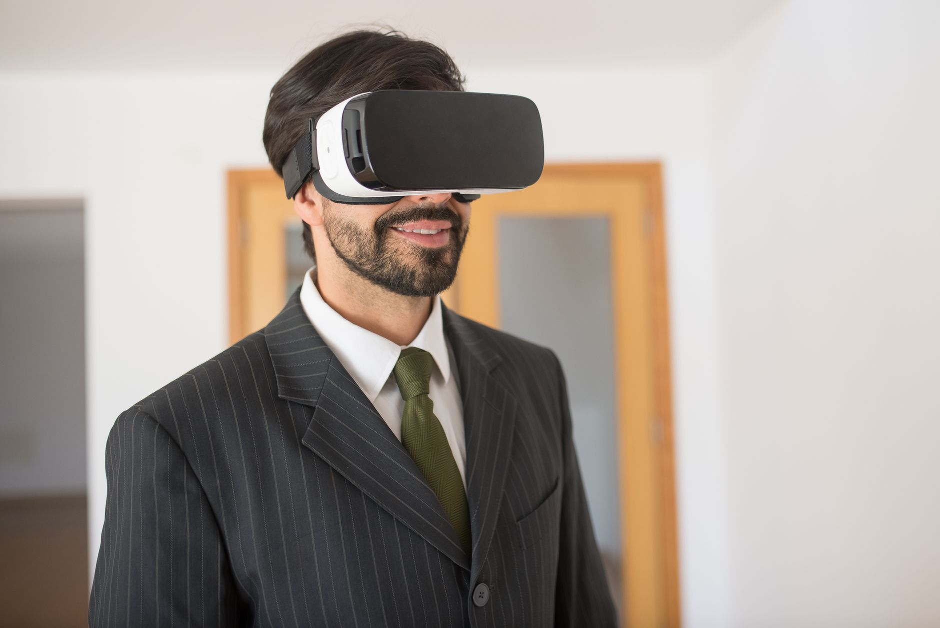 Confident businessman using VR headset in a modern setting.